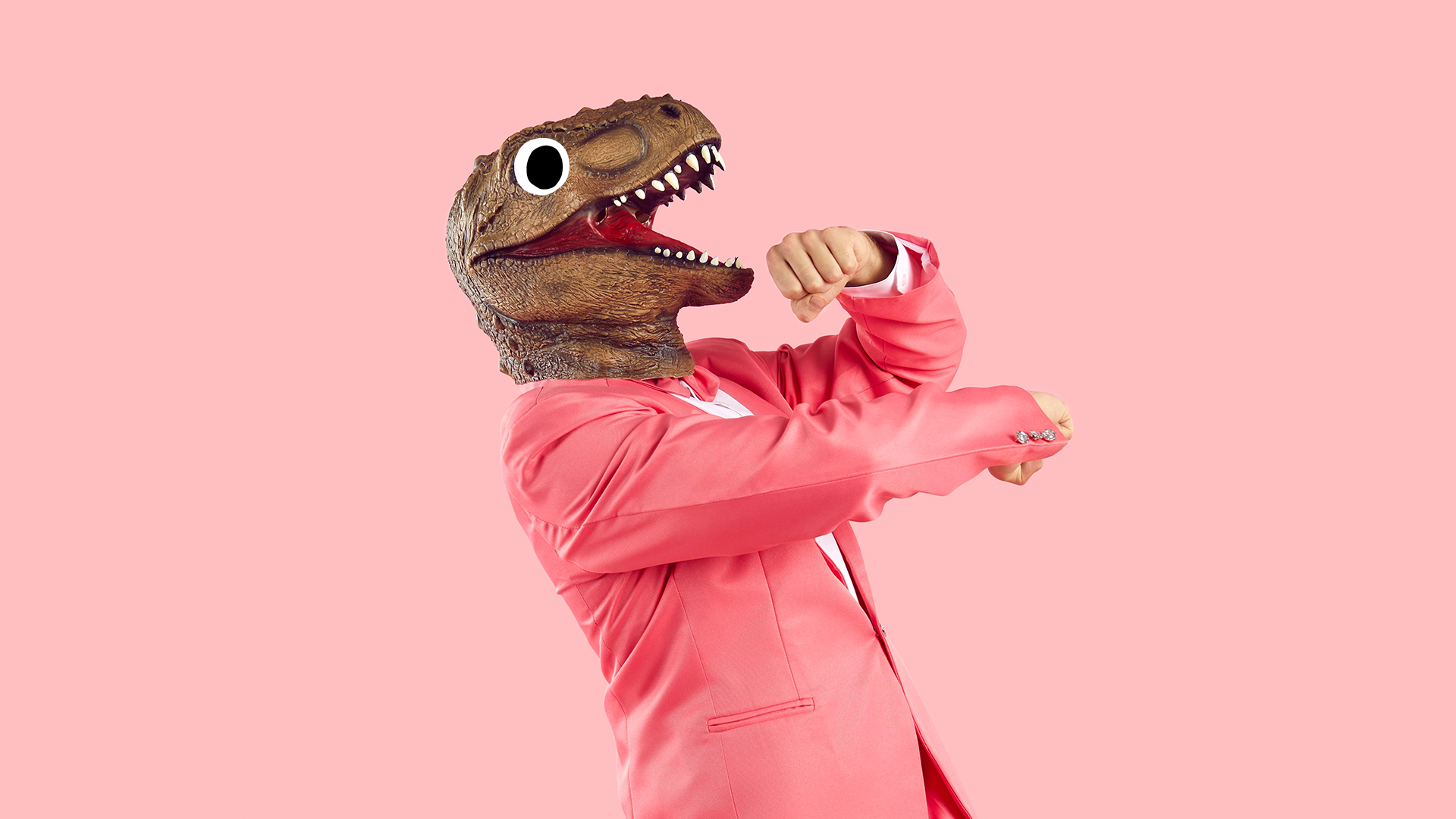 A man in a T-rex mask does a silly dance