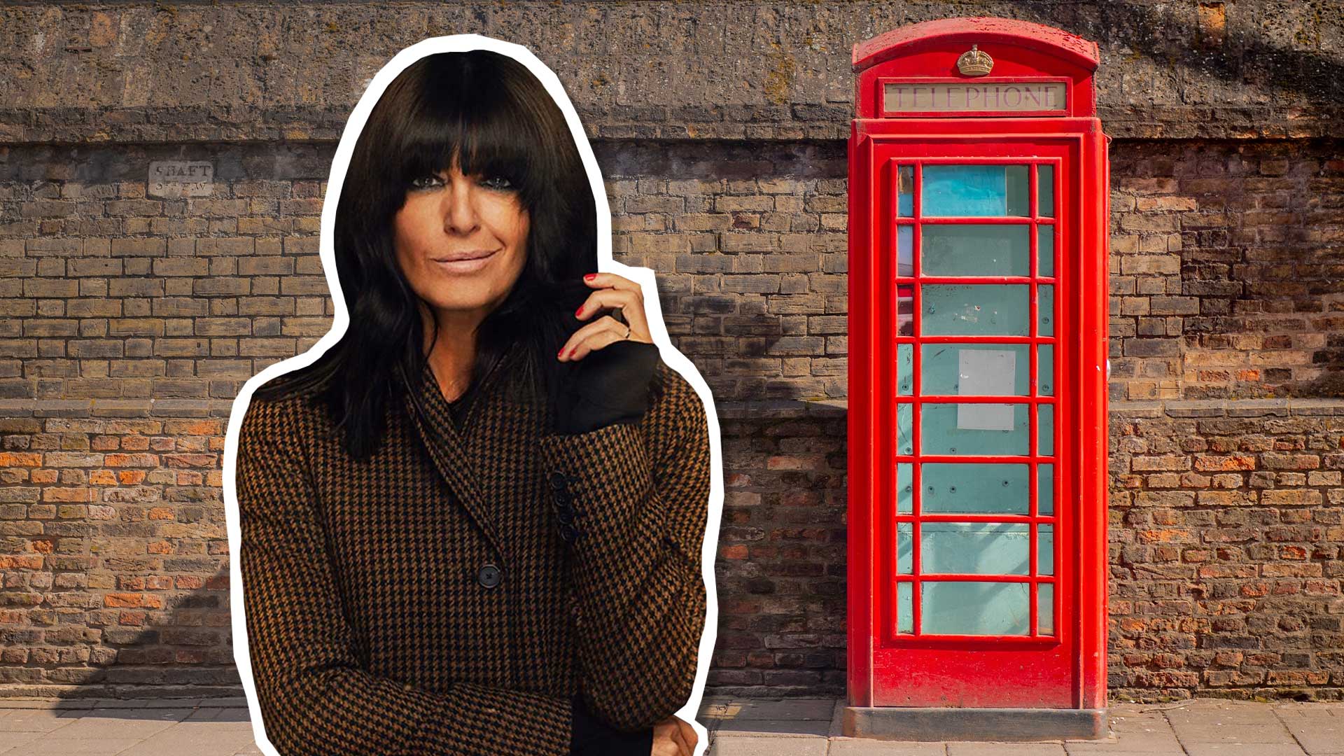 Claudia Winkleman in a street next to an old red telephone box