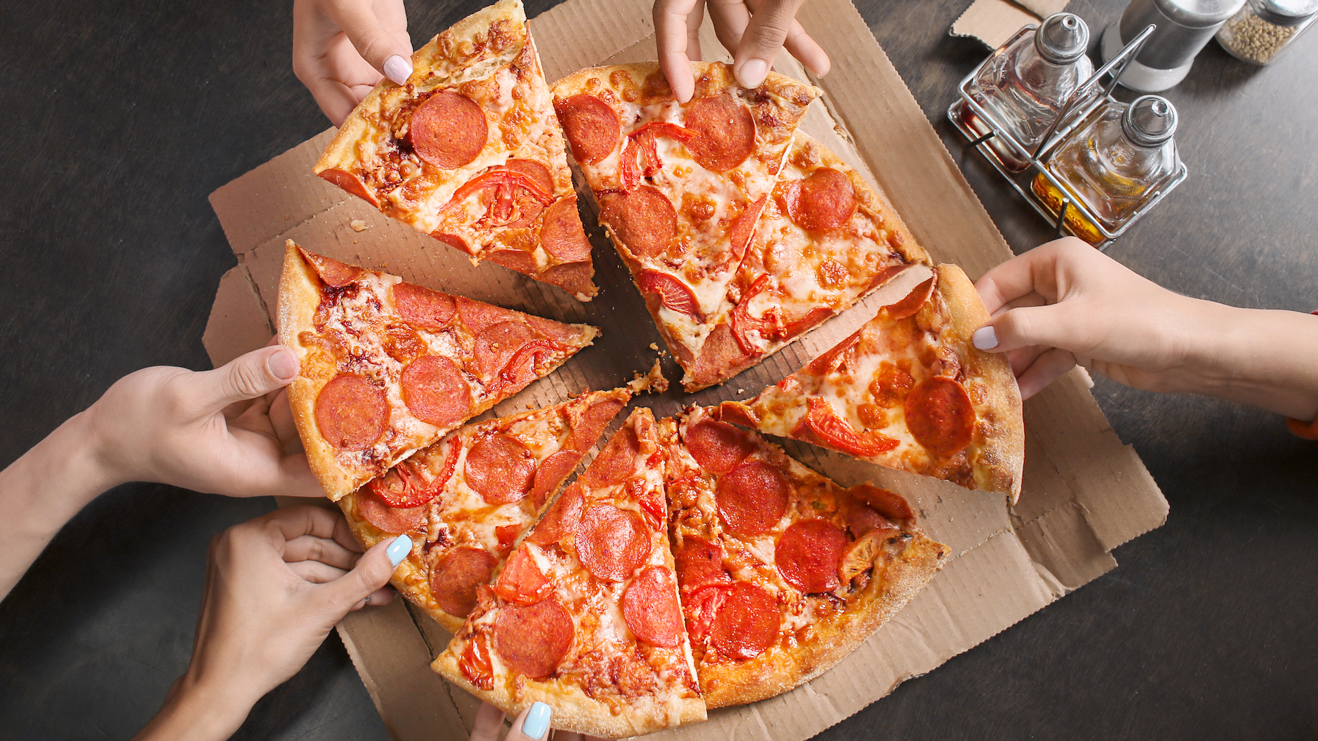 A group of people share a pepperoni pizza