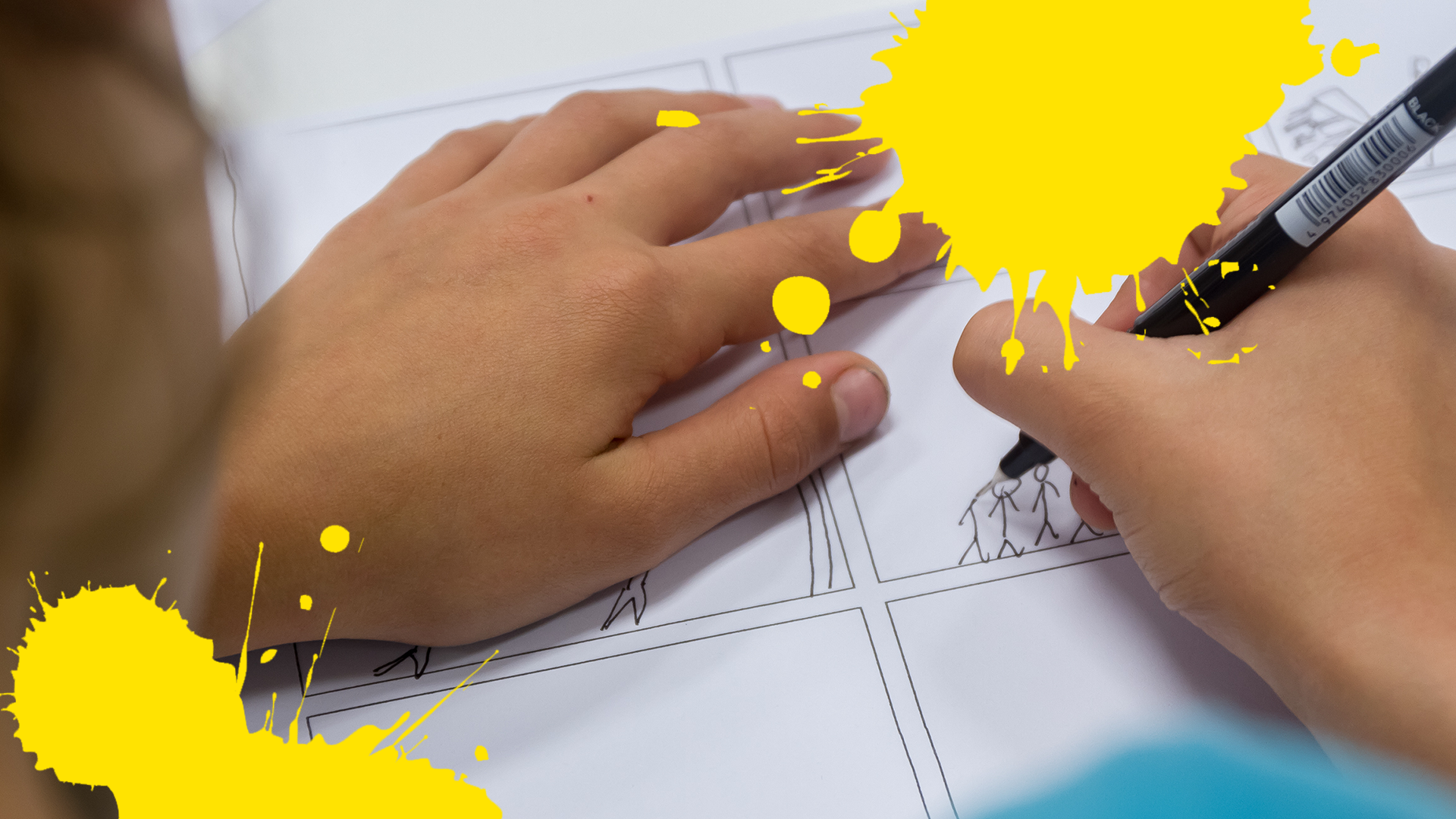Hands drawing comic panel with yellow splats