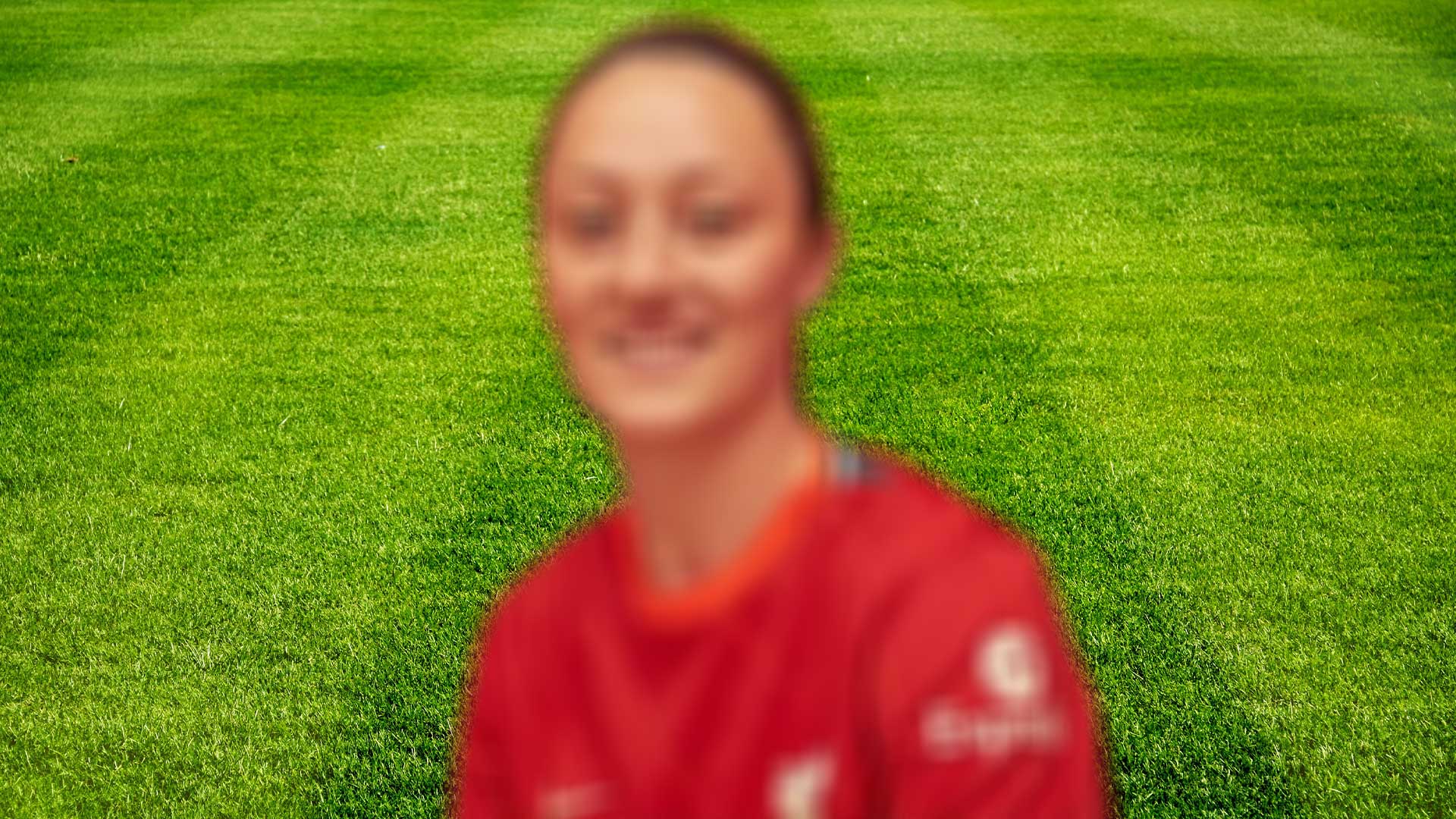 A blurred image of a footballer in a red shirt