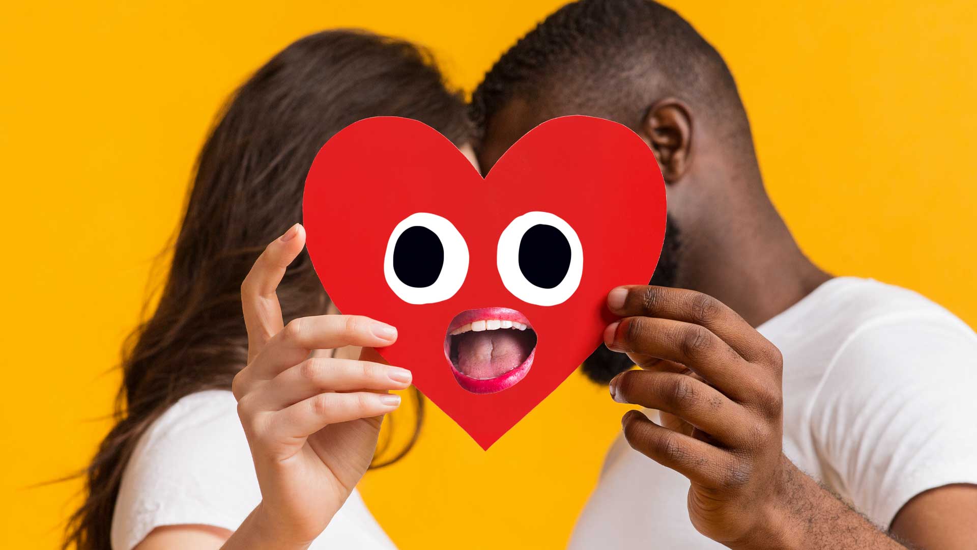 A couple holding a heart-shaped card