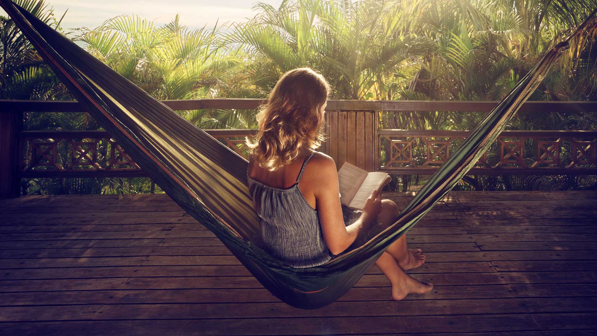 A girl reading a book in a hammock