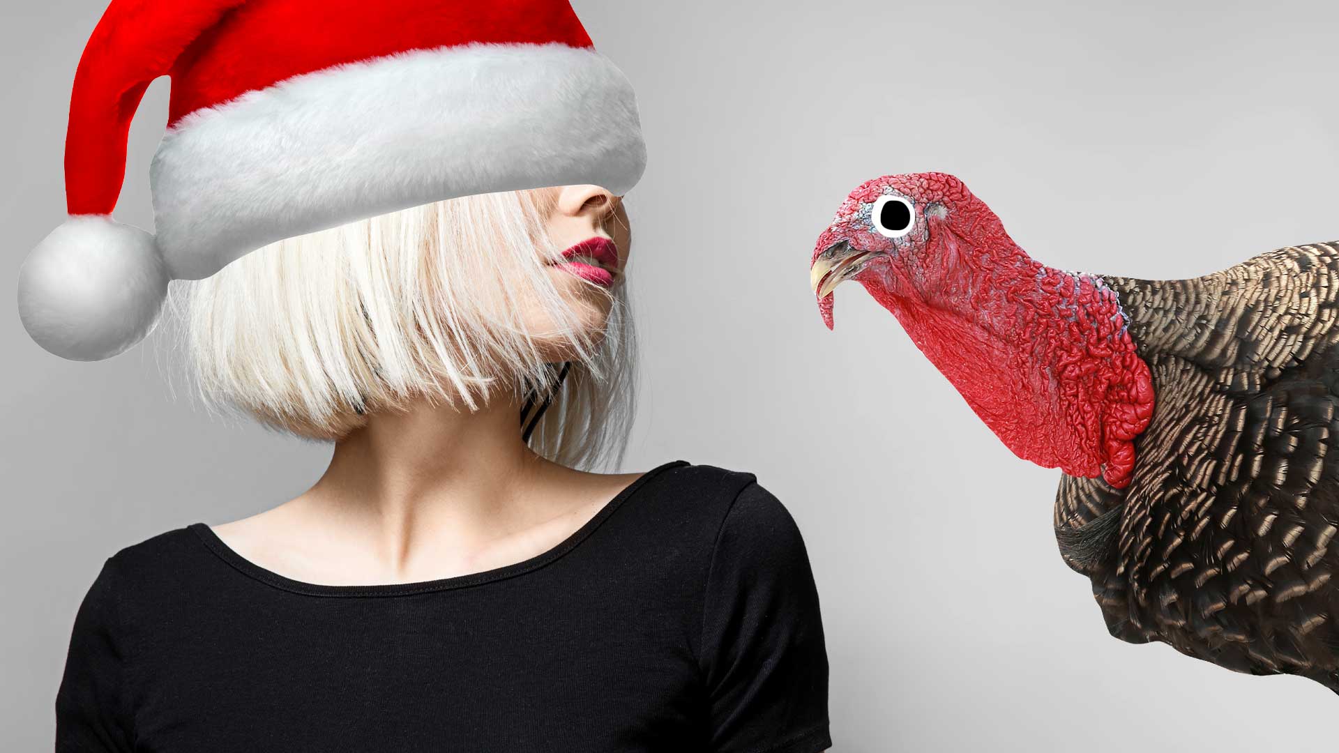 A woman in a Christmas hat being stared at by a turkey