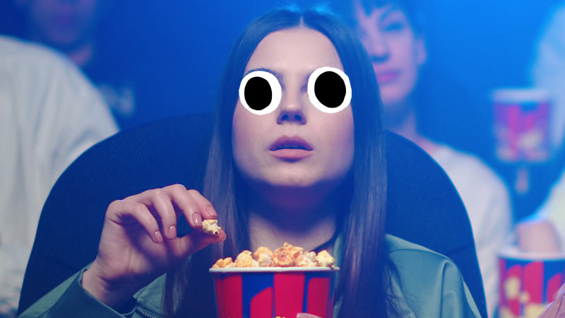 A person eating popcorn in a cinema
