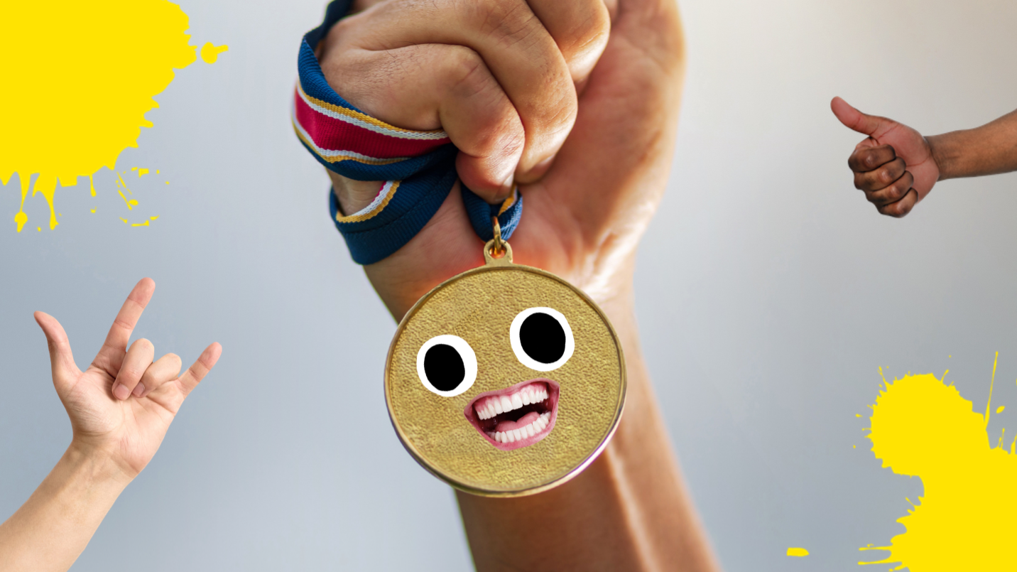 A hand clutching a gold medal