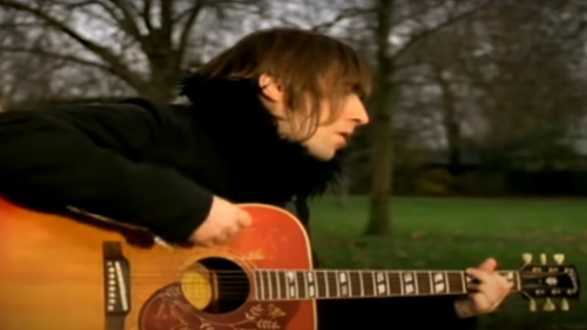 Liam Gallagher playing the acoustic guitar