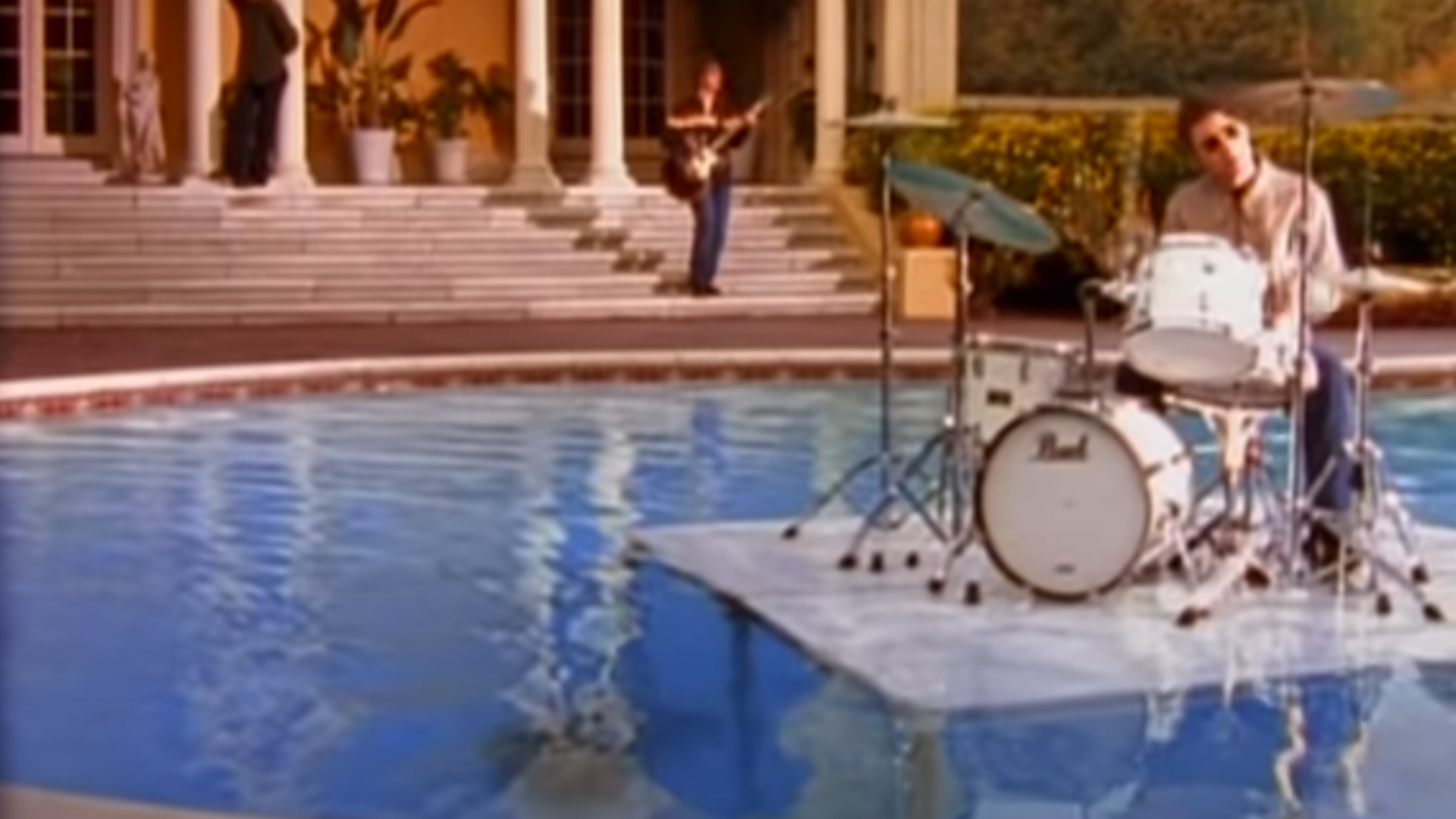 Oasis' drummer playing drums in a pool