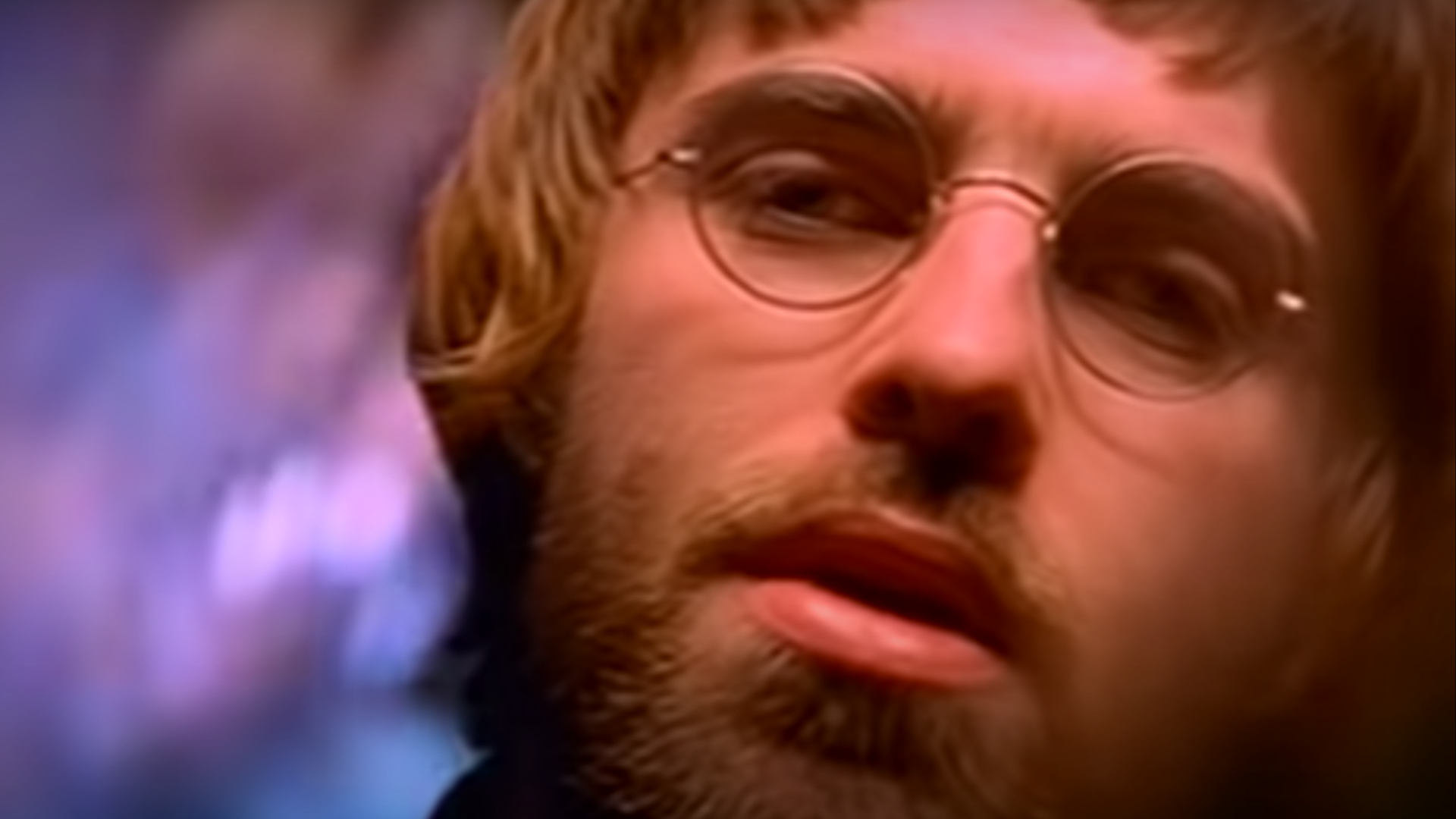 Liam Gallagher in a beard and round glasses