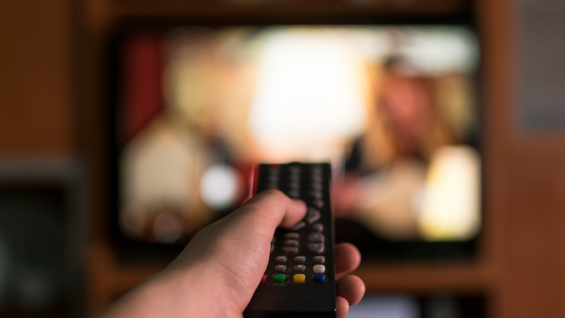 closeup of hand holding a television remote control