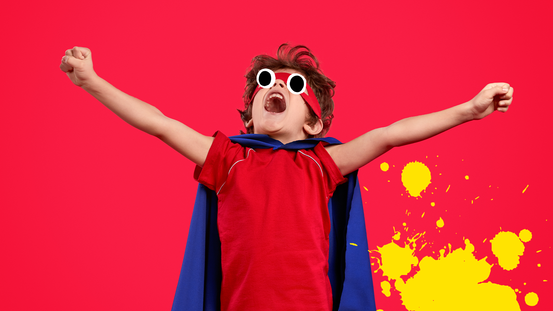 Boy dressed as superhero on red background 