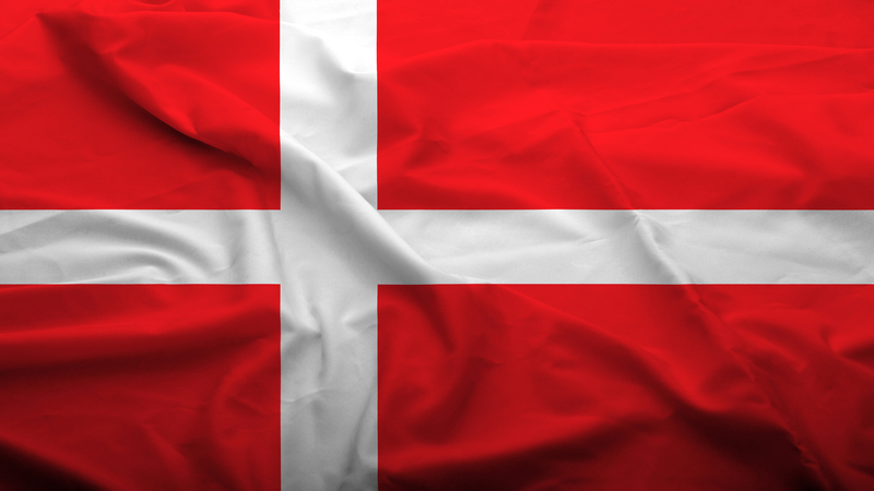 A flag. An off centre white cross on a red background.