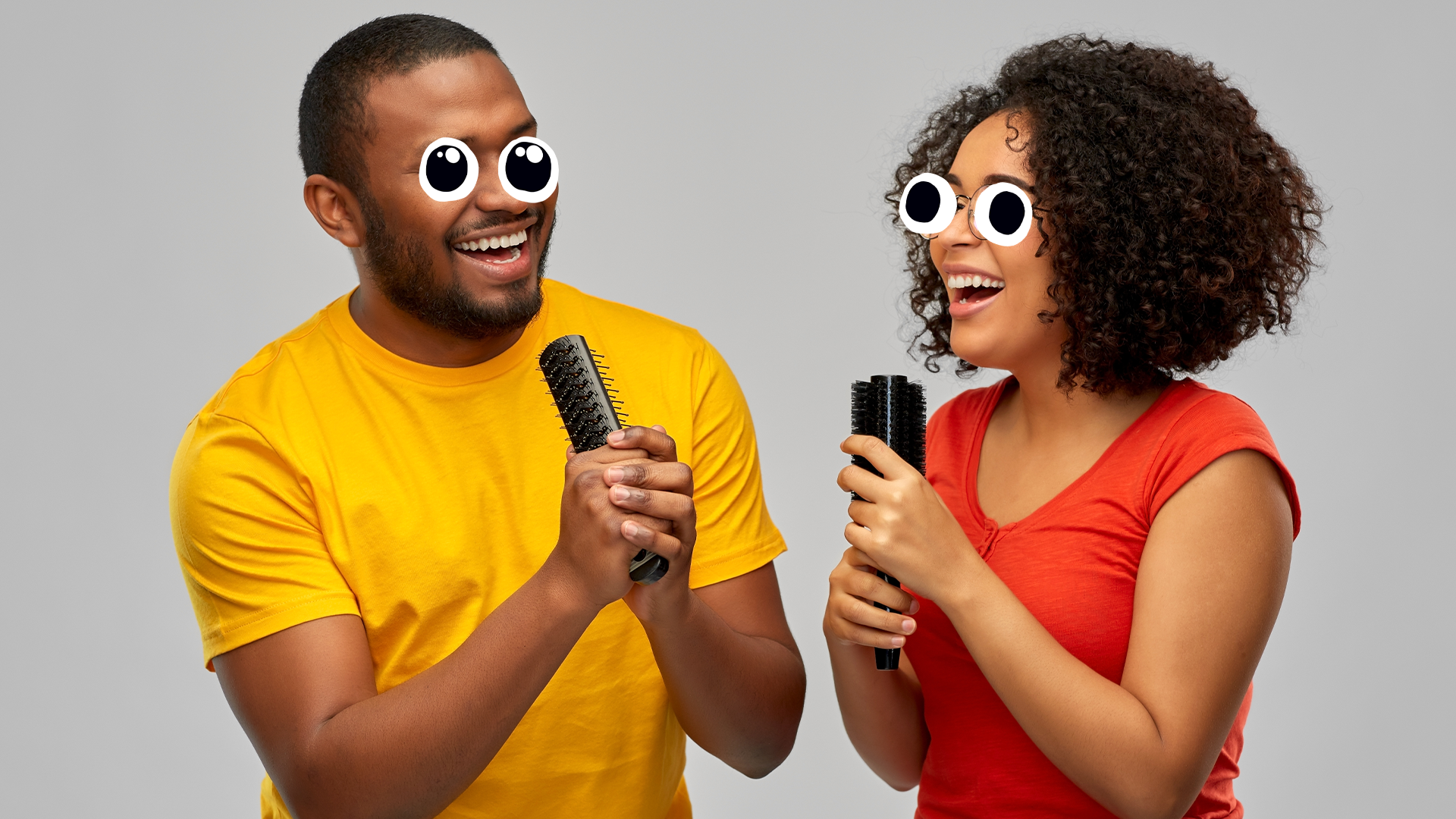 Man and woman singing into hairbrushes