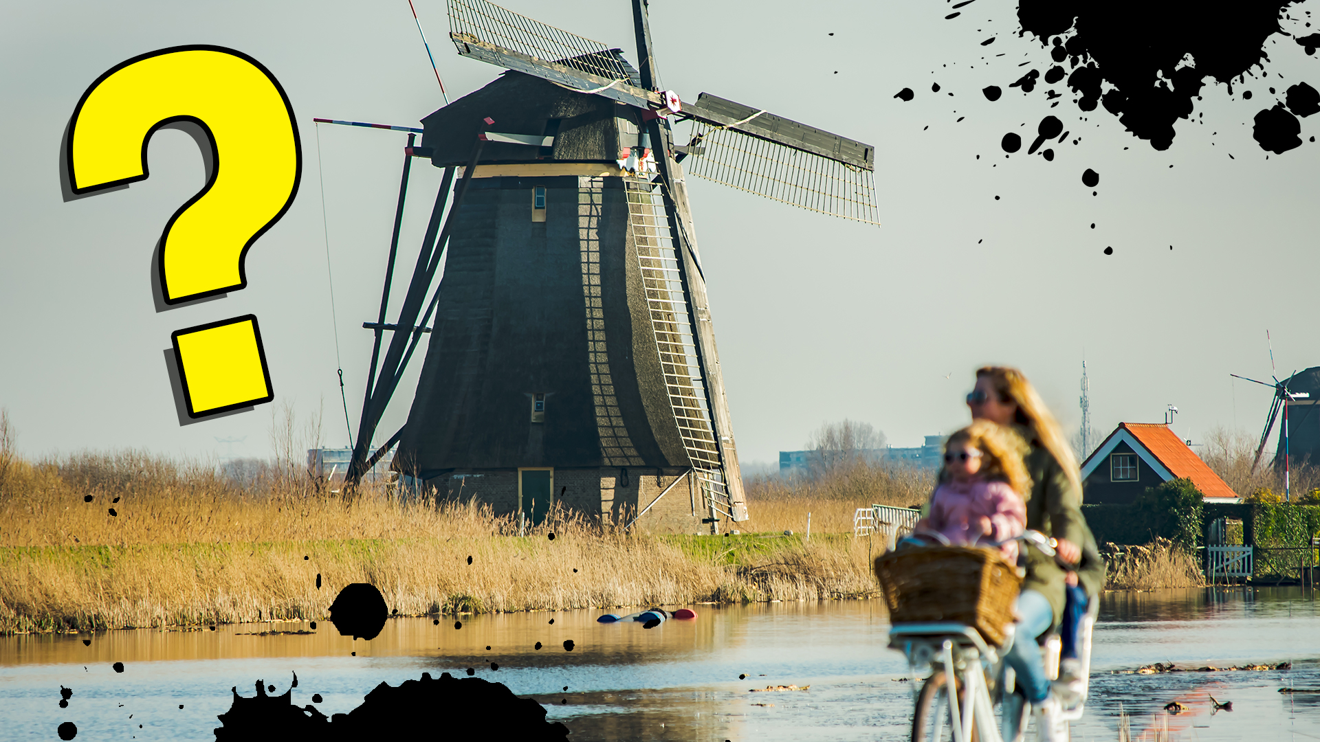 Some Dutch people cycle past a windmill