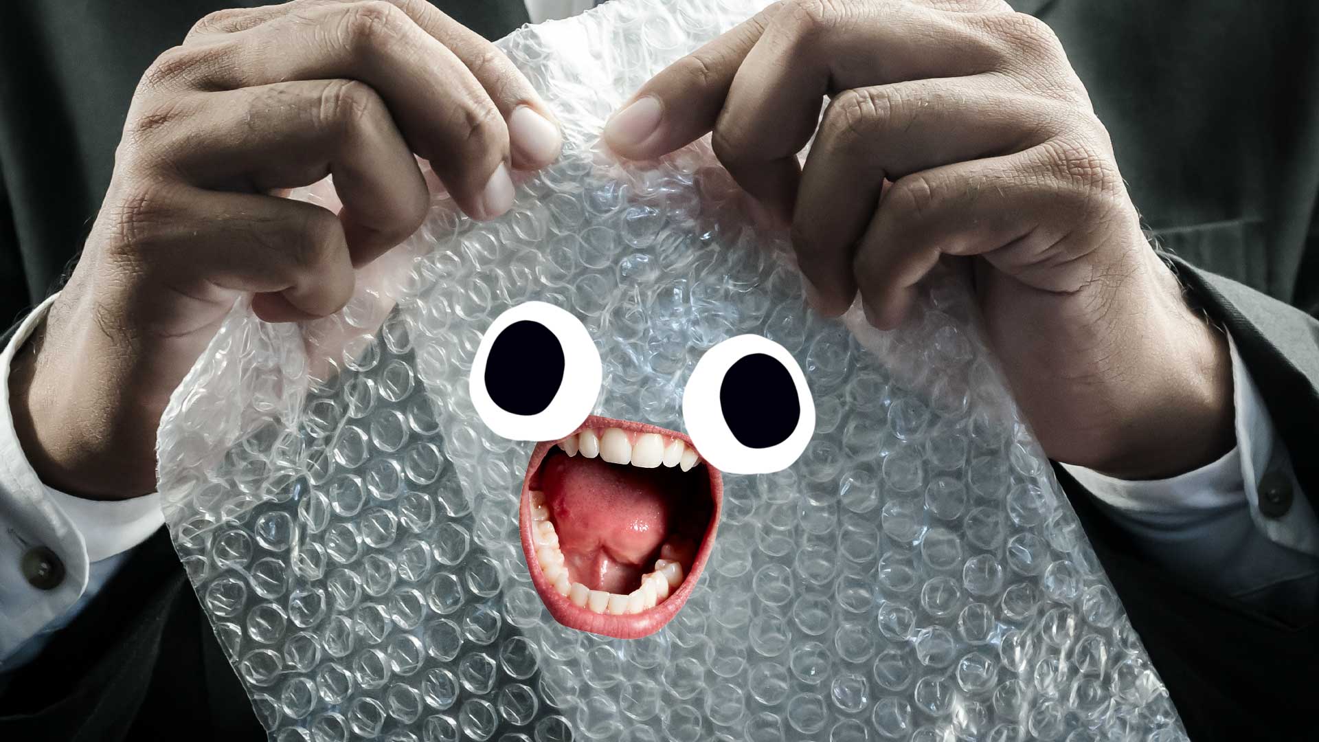 A man in a suit popping bubble wrap