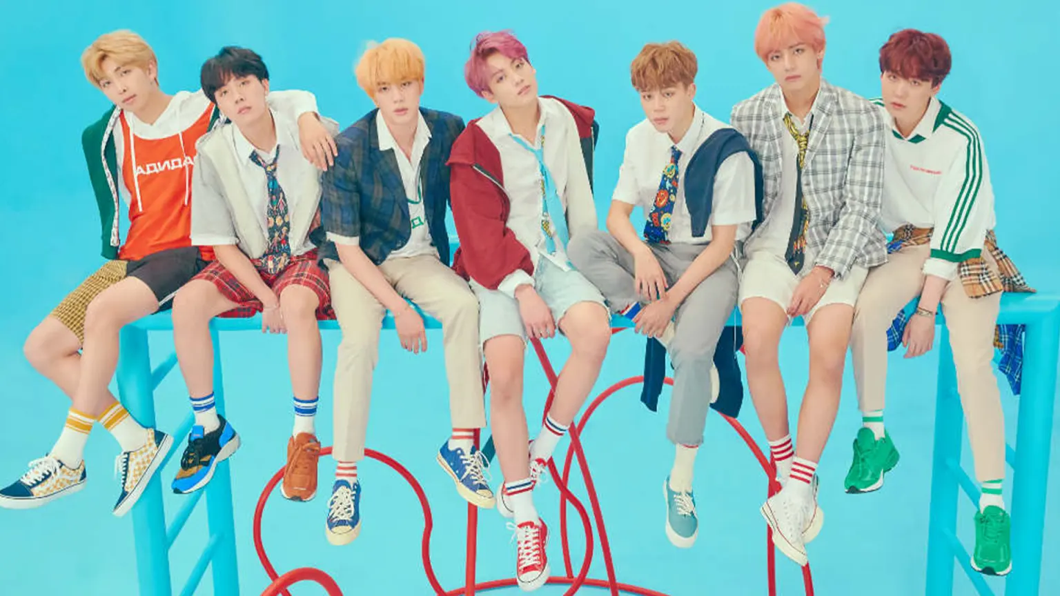 BTS sitting on some kind of climbing frame