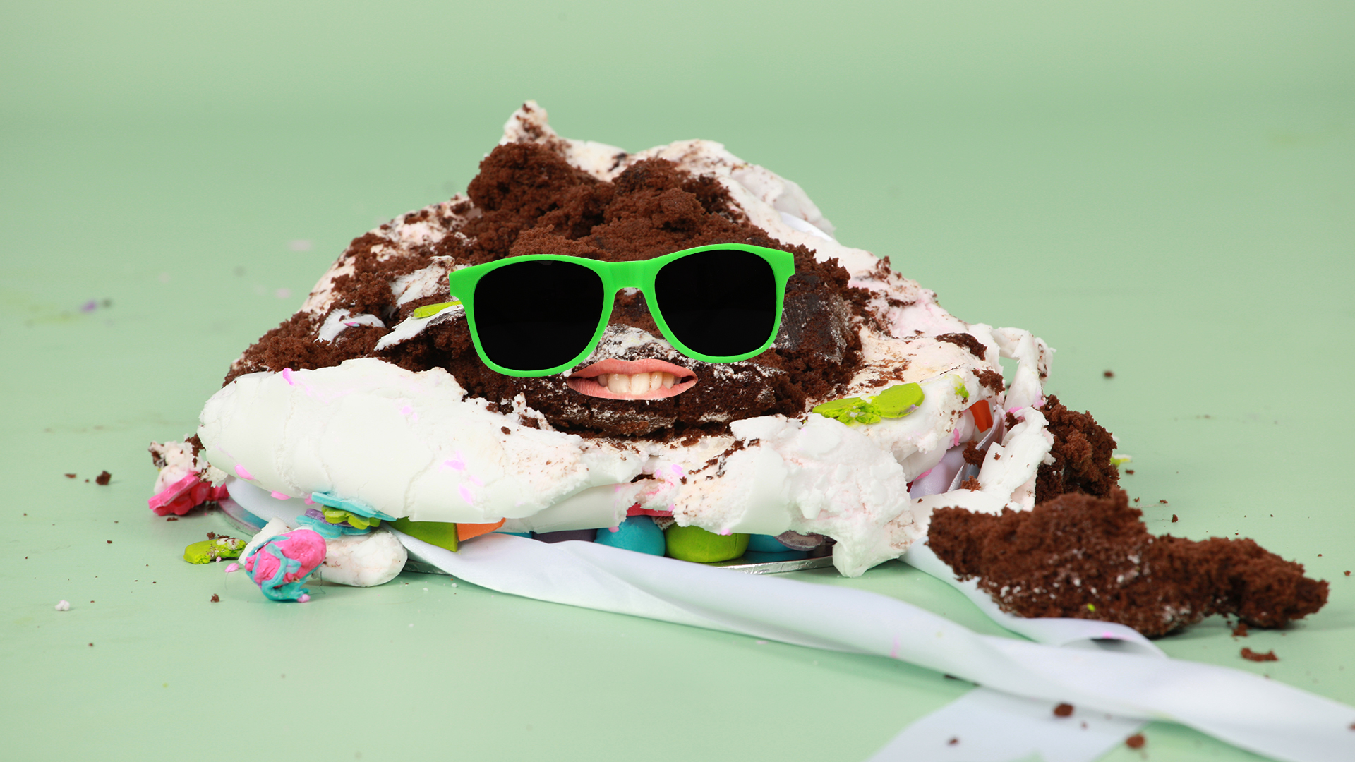 A smiling chocolate cake that is wearing sunglasses