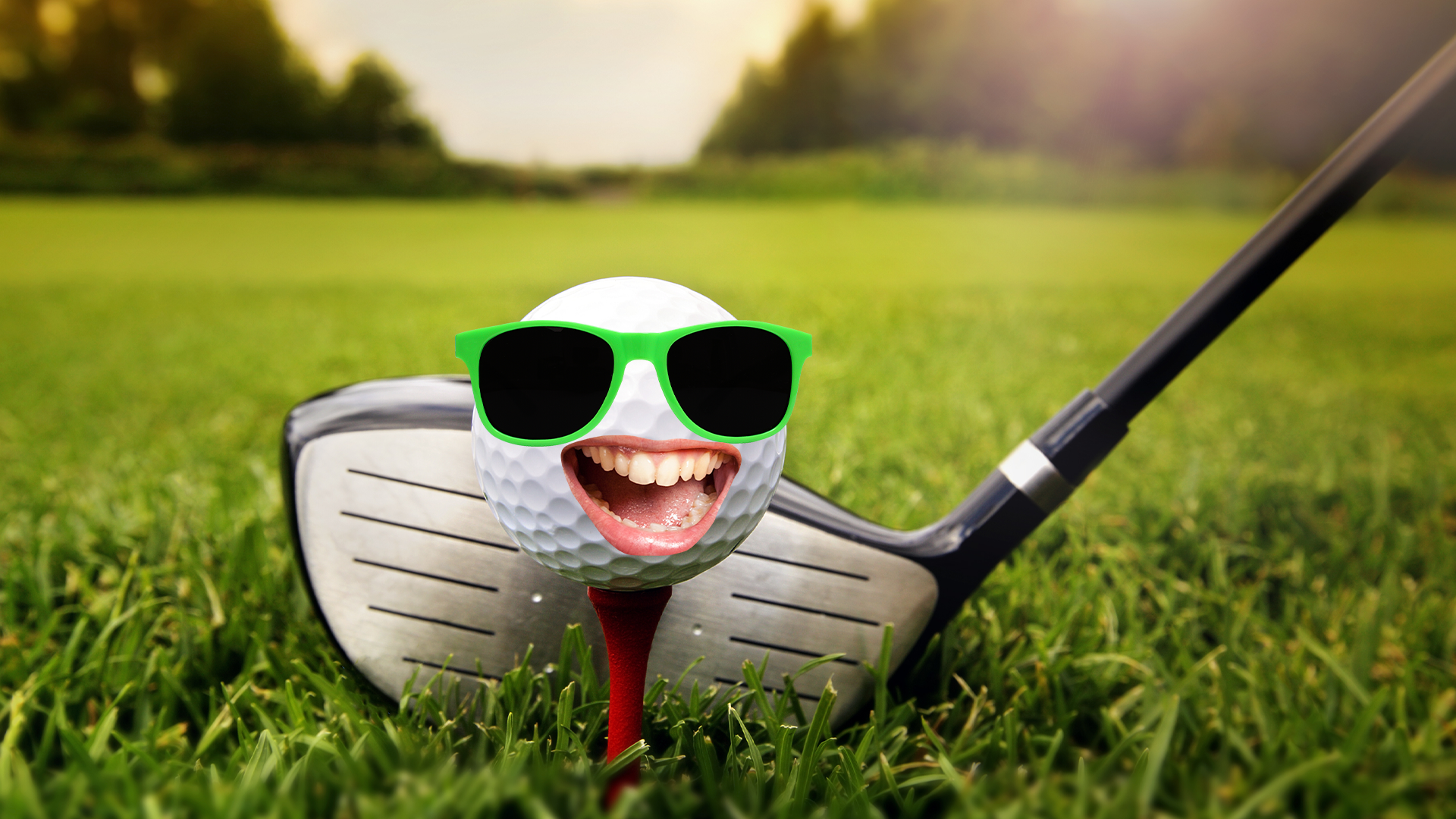 Golf ball with goofy face and club on grass