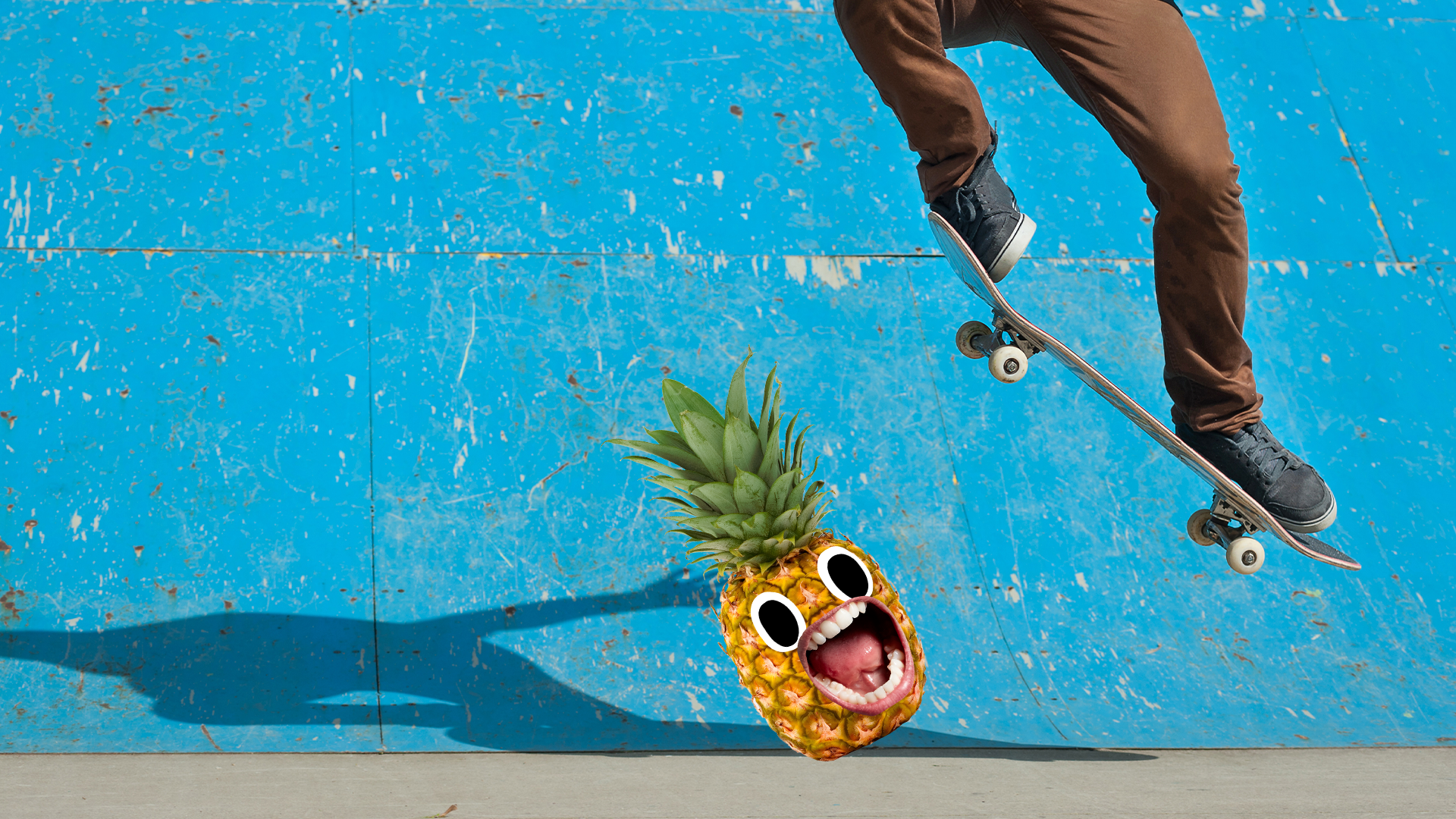 Pinapple screams as skateboarder jumps over it on blue ramp