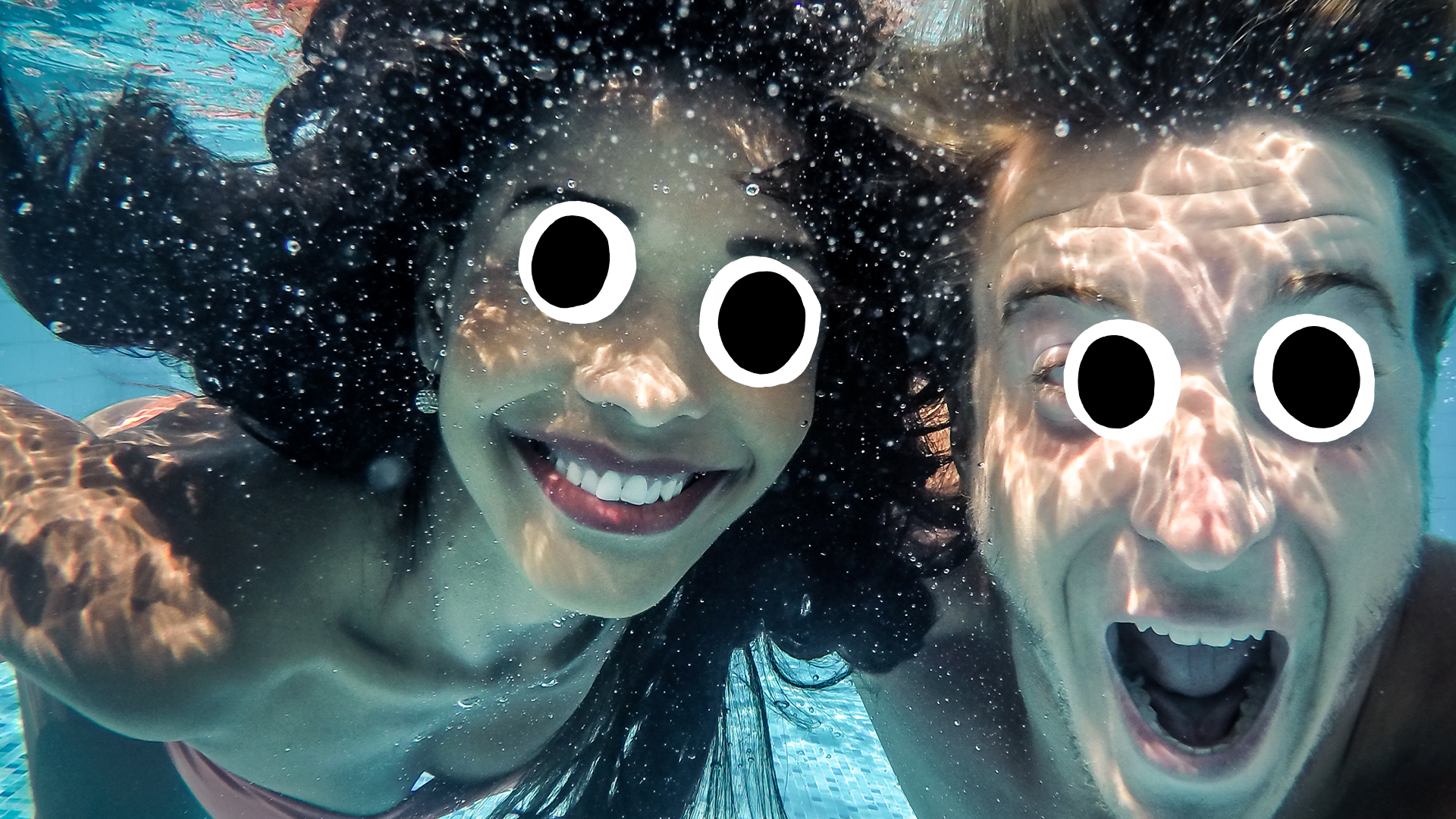 Man and woman underwater smiling at camera
