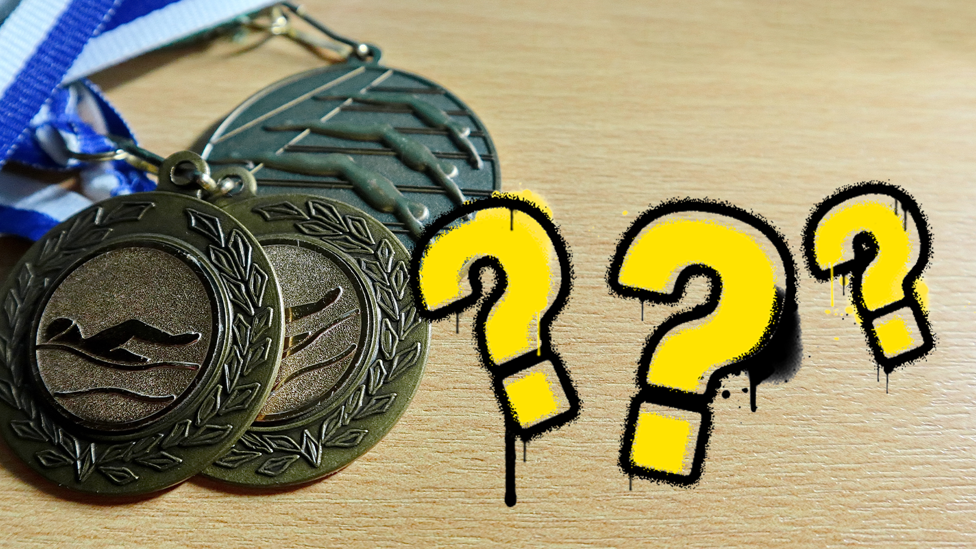 Swimming medals with question marks 