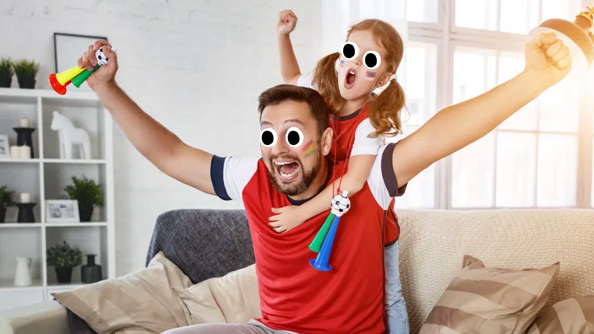 A dad and daughter watching the football on telly