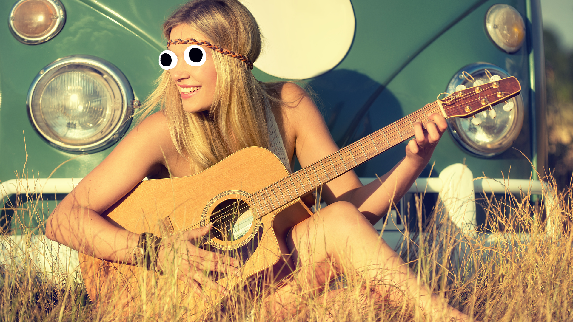 Girl playing guitar in a field
