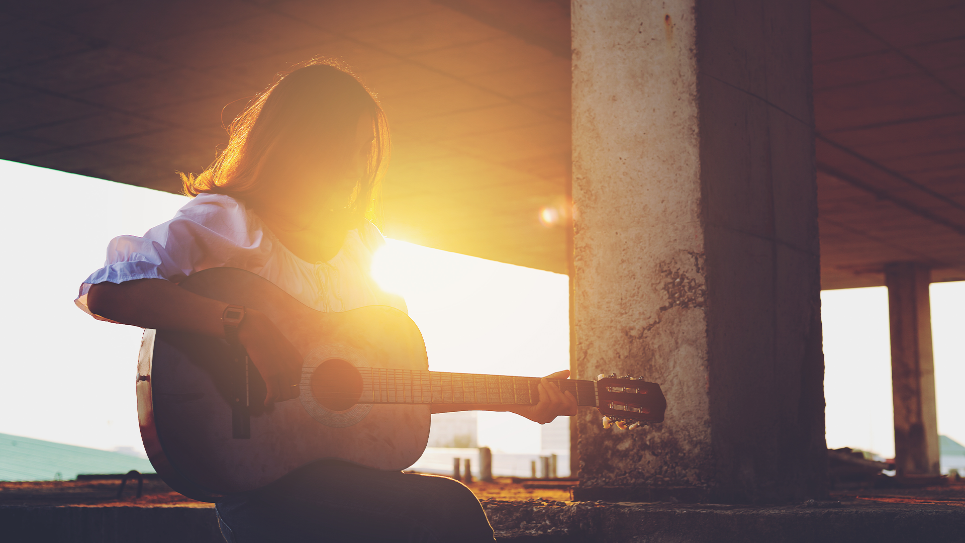 Girl with guitar in sunset