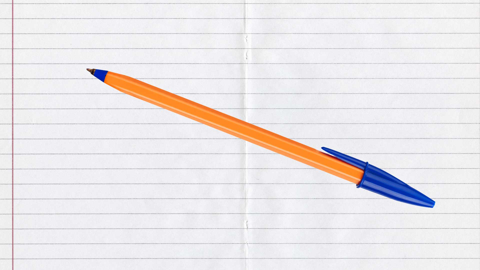A ballpoint pen rests on a sheet of lined paper