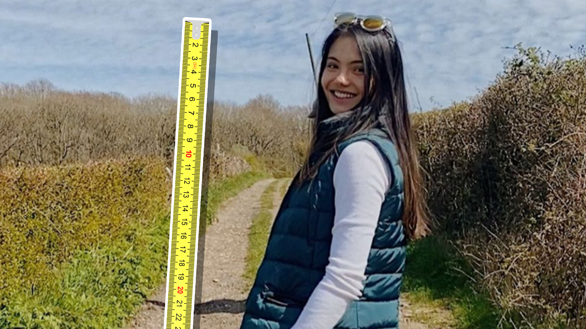 Emma Raducanu walking down a country road alongside a measuring tape