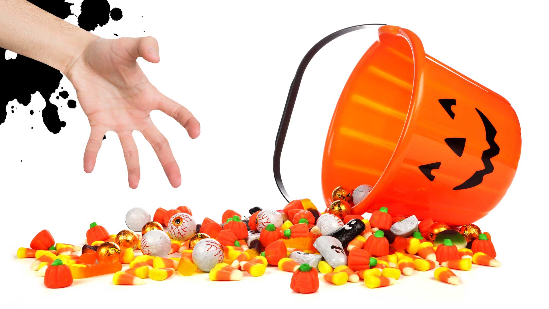 A hand reaching for a bucket of spilled Halloween sweets