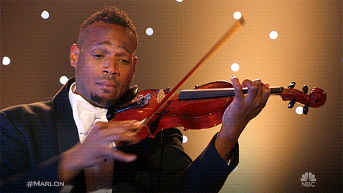 Comedian Marlon Wayans playing a violin