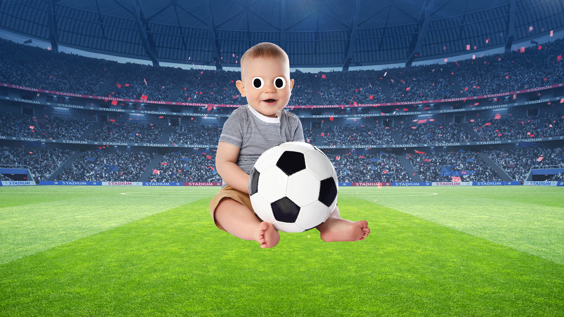 A baby holding a football in a big stadium