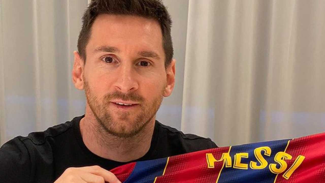 Lionel Messi holding a Barcelona shirt