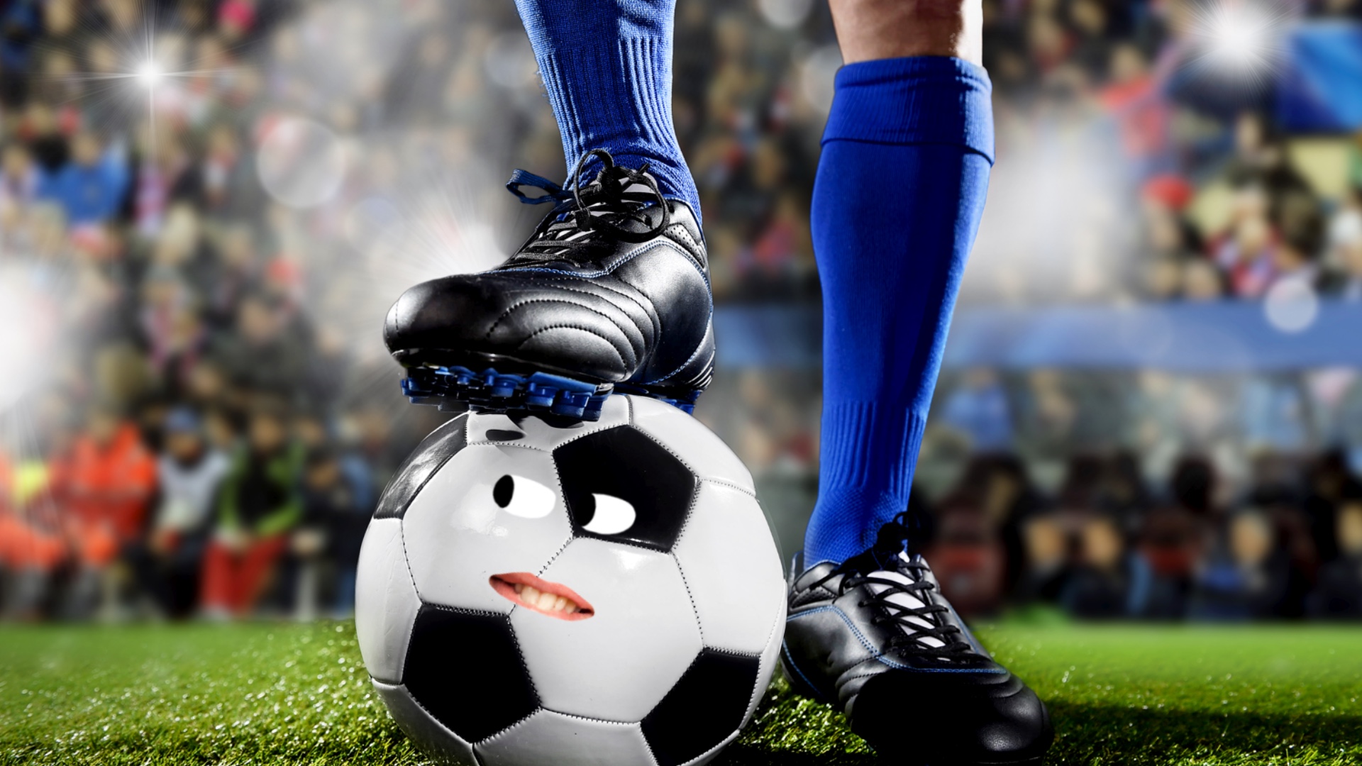 A footballer in blue socks with their boot on a ball