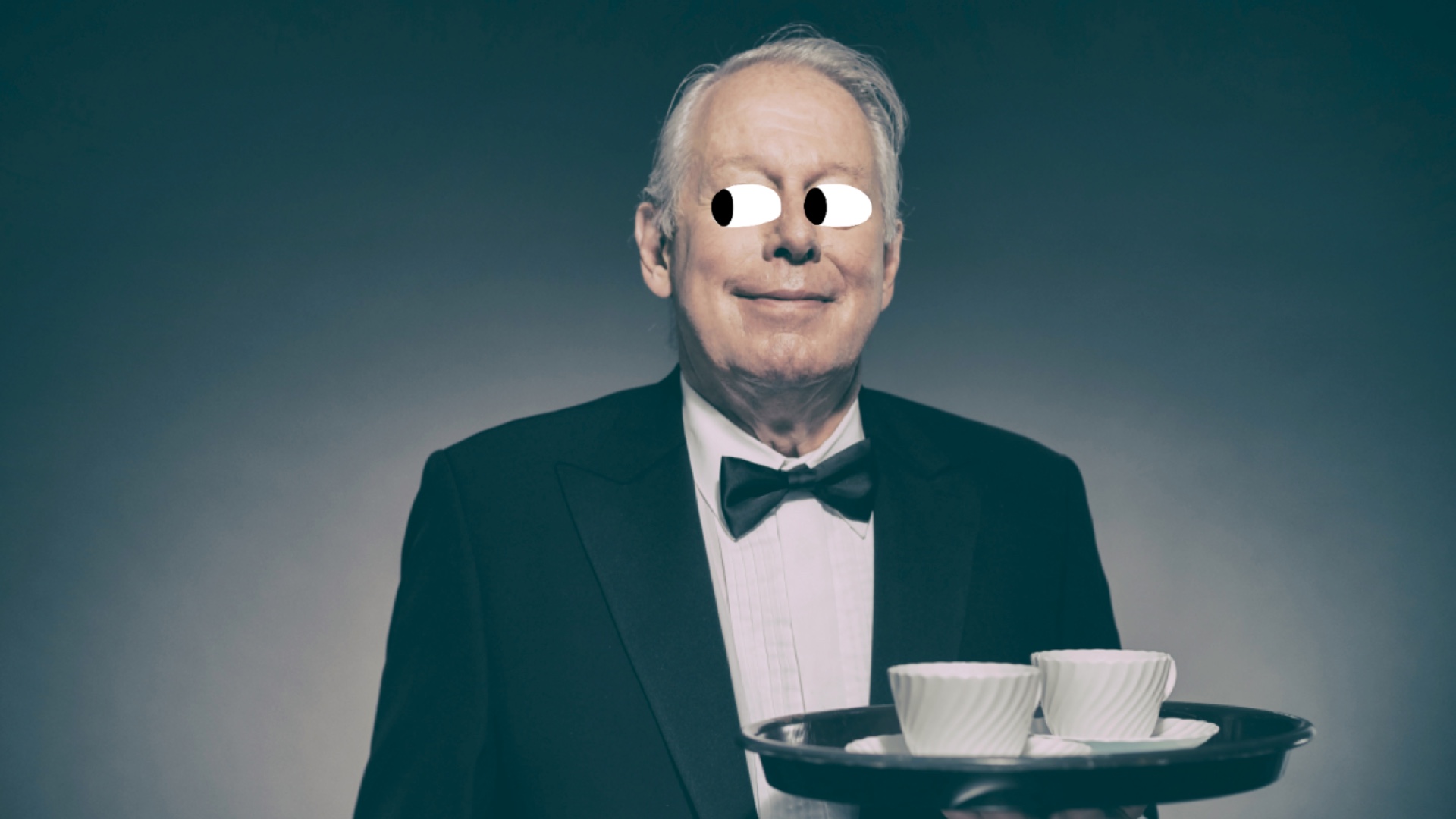 A butler holding a tray with cups and saucers on it