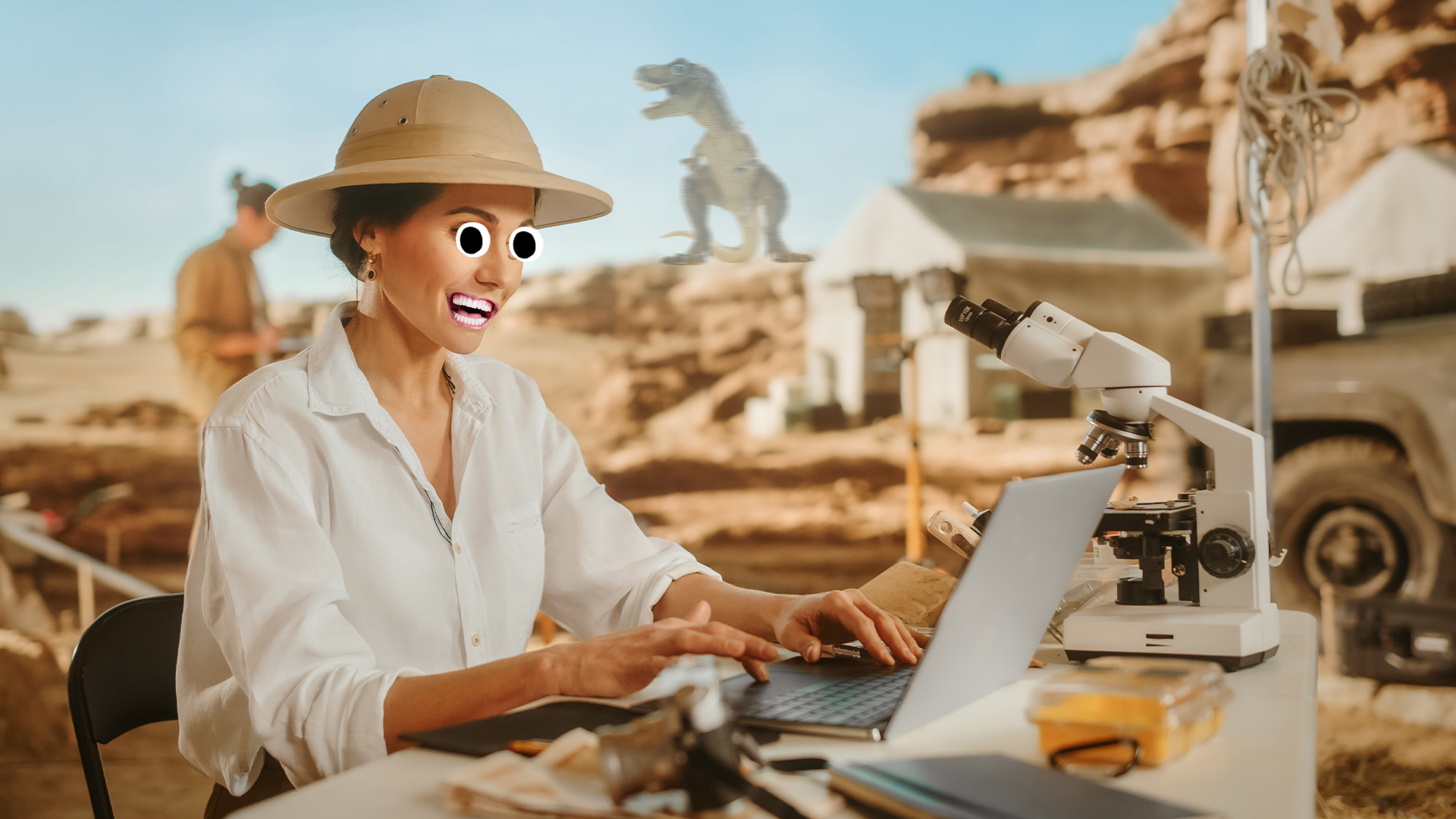A woman researches something on a laptop at an archaeological dig