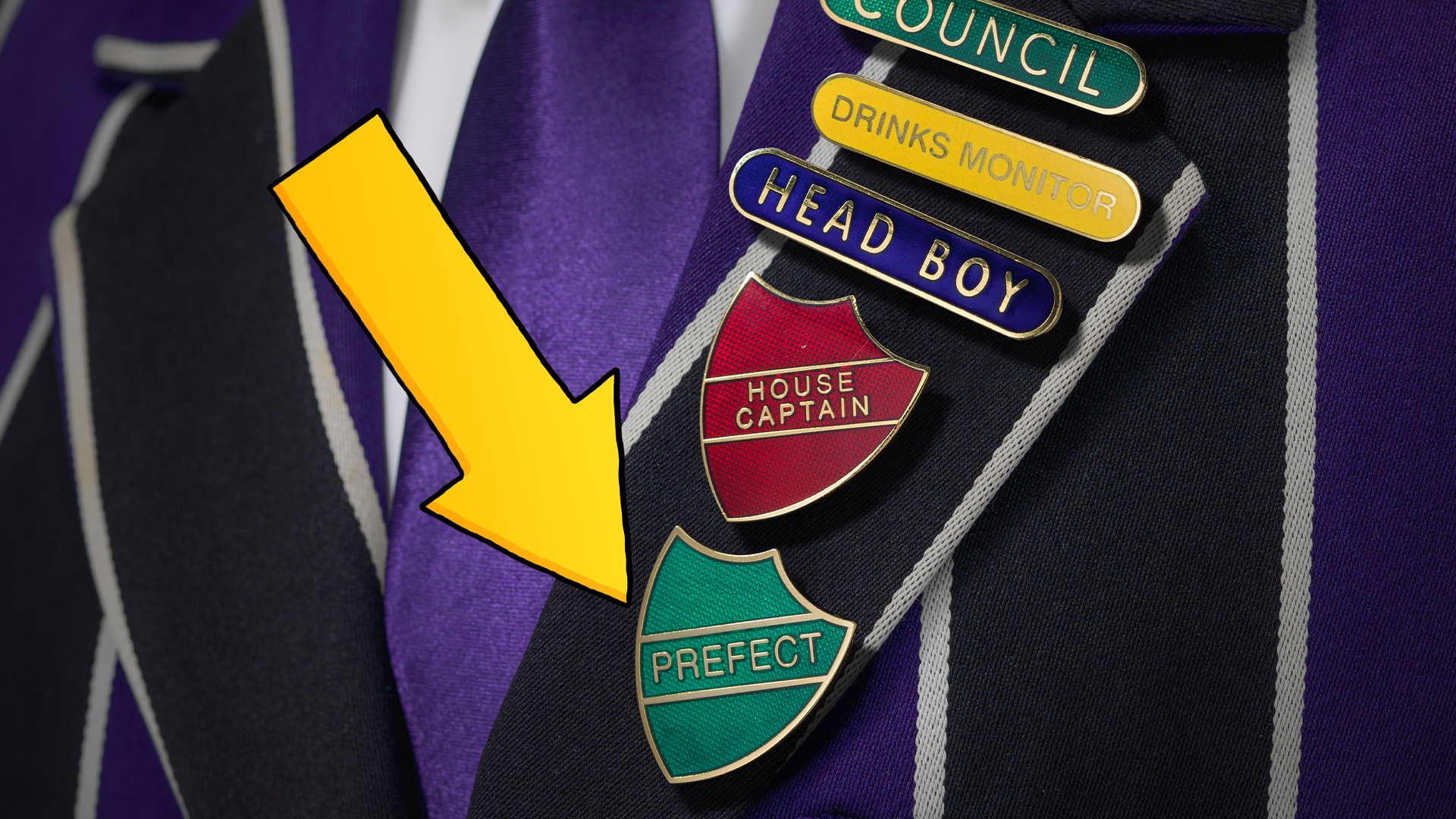 Arrow pointing to prefect badges