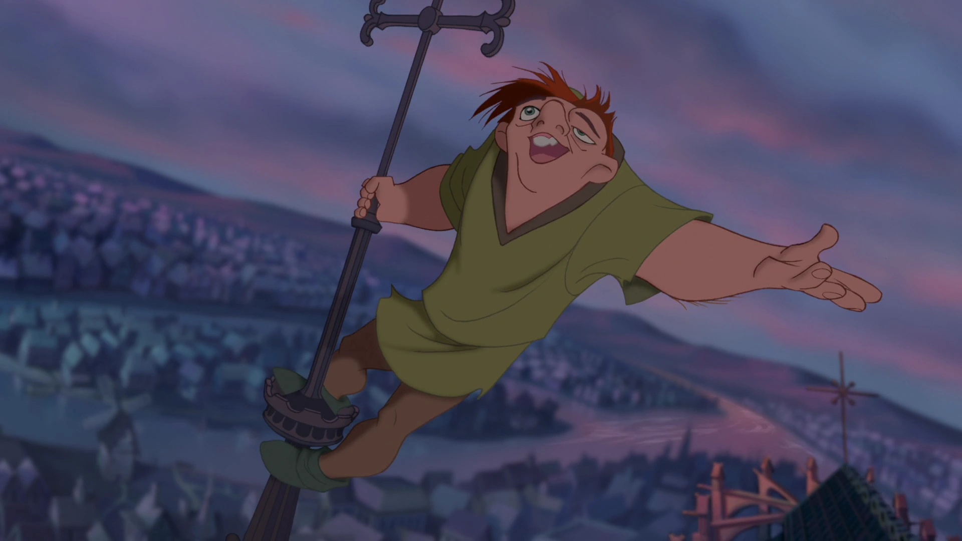 A still from "The Hunchback of Notre Dame", featuring Quasimodo singing on top of the cathedral