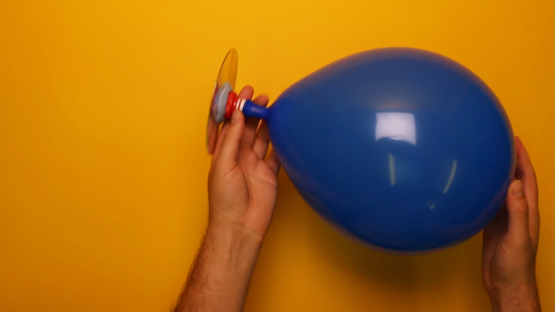 Inflate the balloon by blowing through the hole in the CD. Close the sports cap to keep the air in!