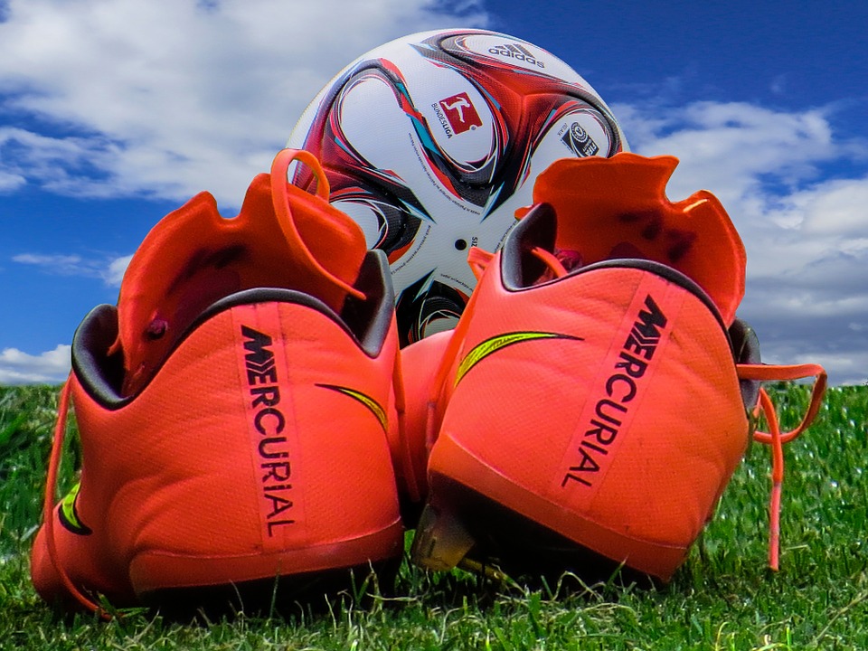 A pair of football boots and a football