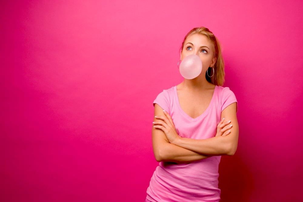 A lady enjoying some bright pink bubblegum