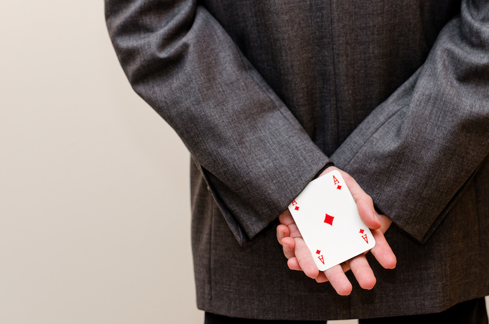 A man with a card up his suit sleeve