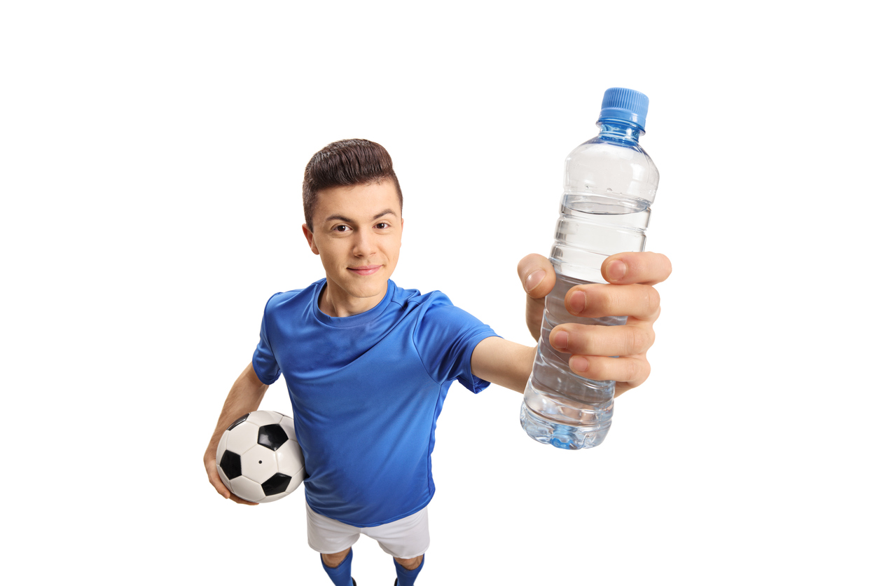 A football player drinks a bottle of water