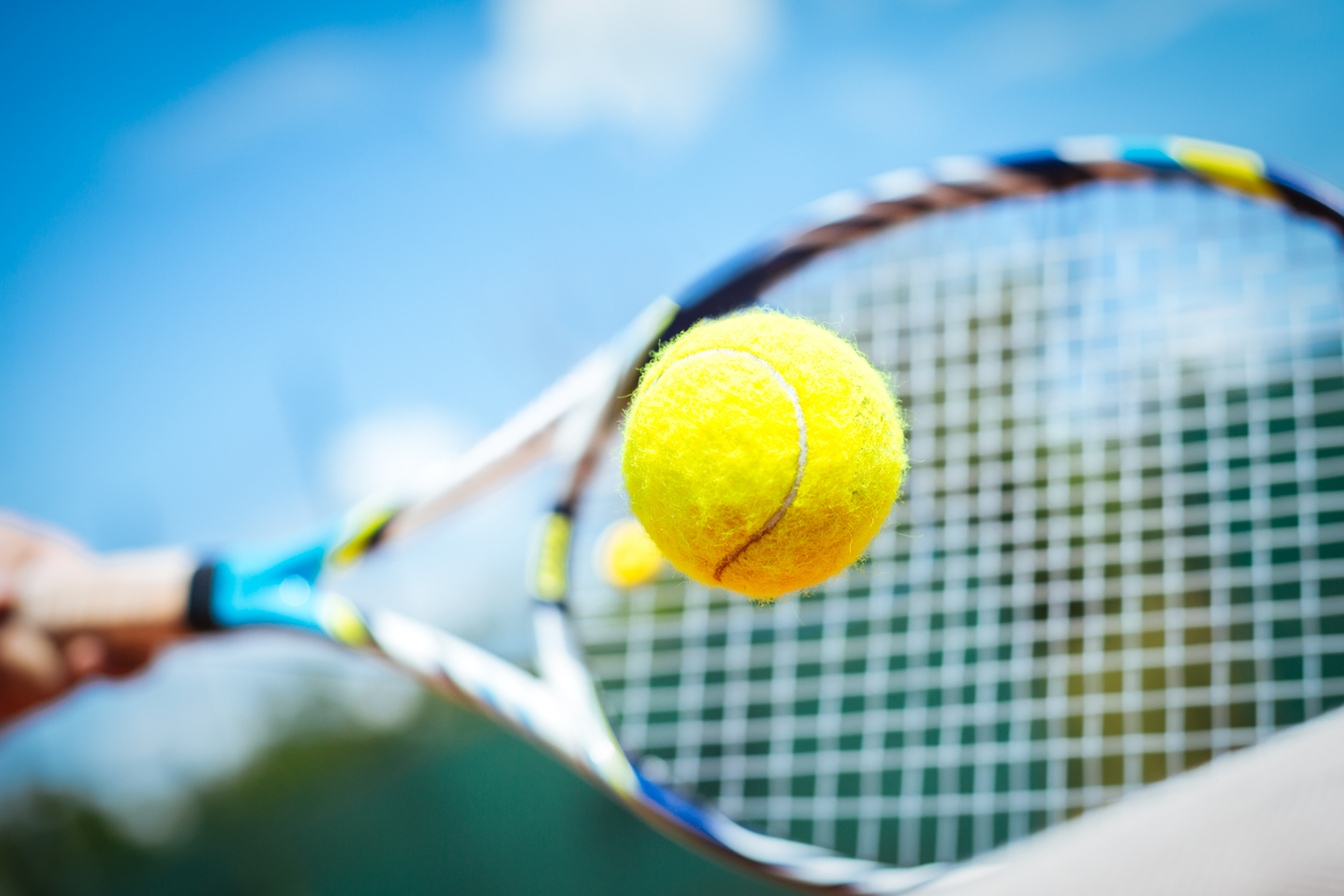 A tennis racquet striking the ball