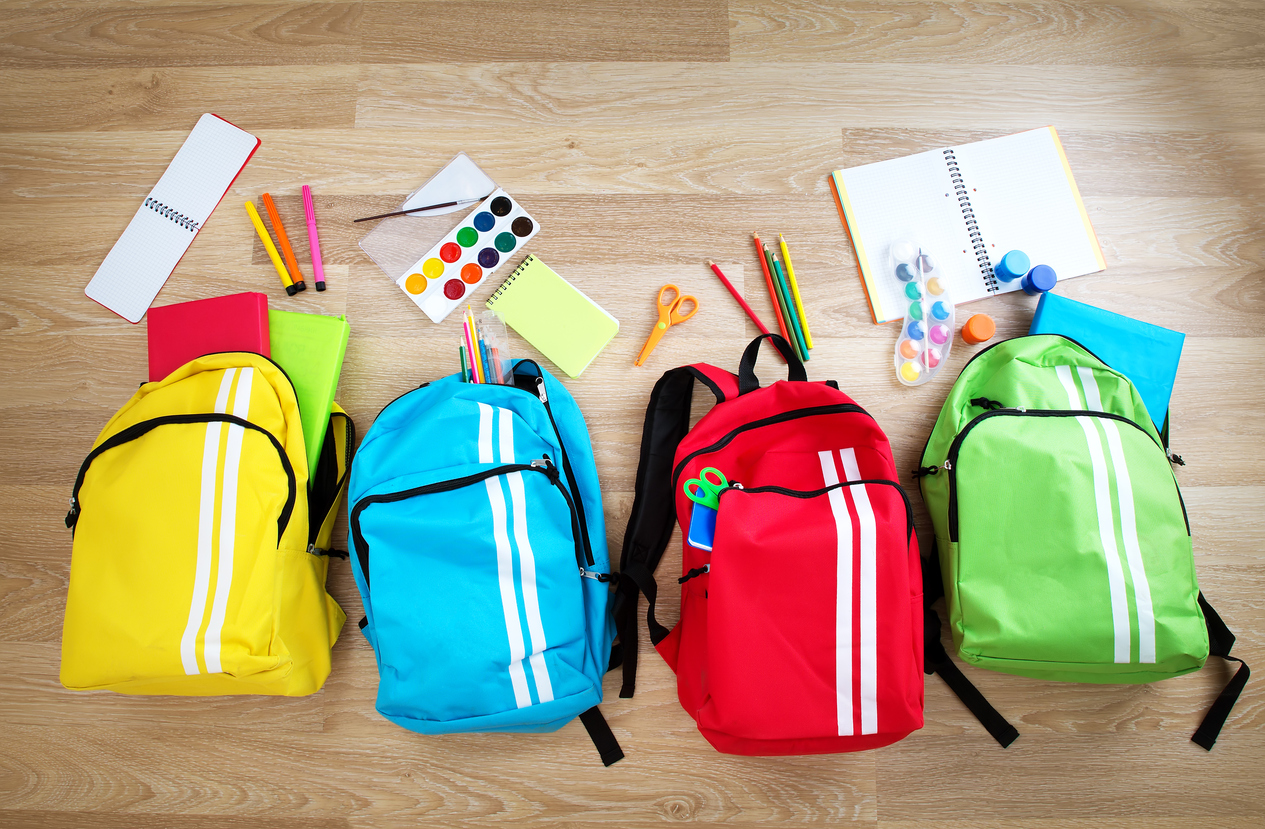 Colourful schoolbags on a wooden floor
