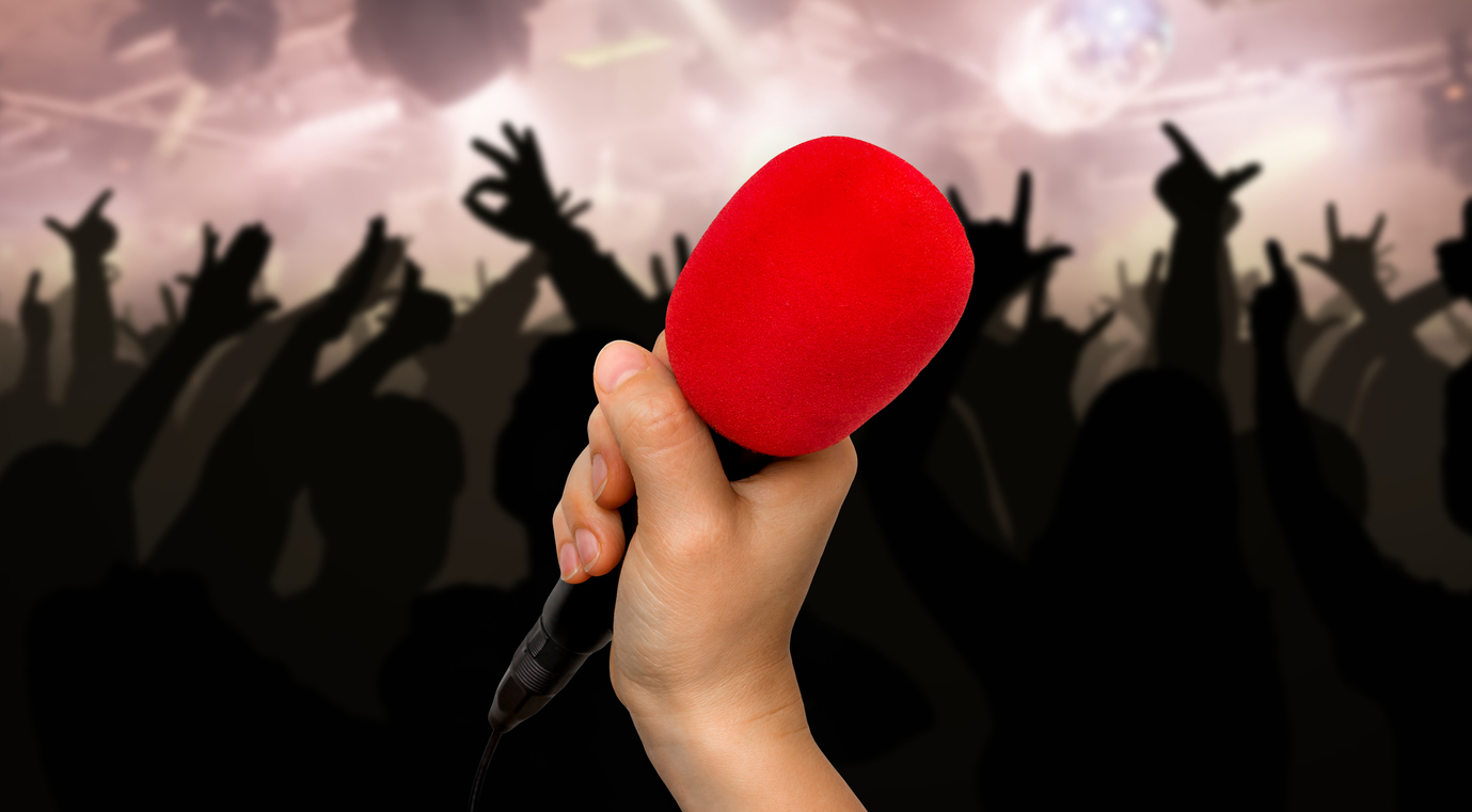 A hand holds a microphone at a concert