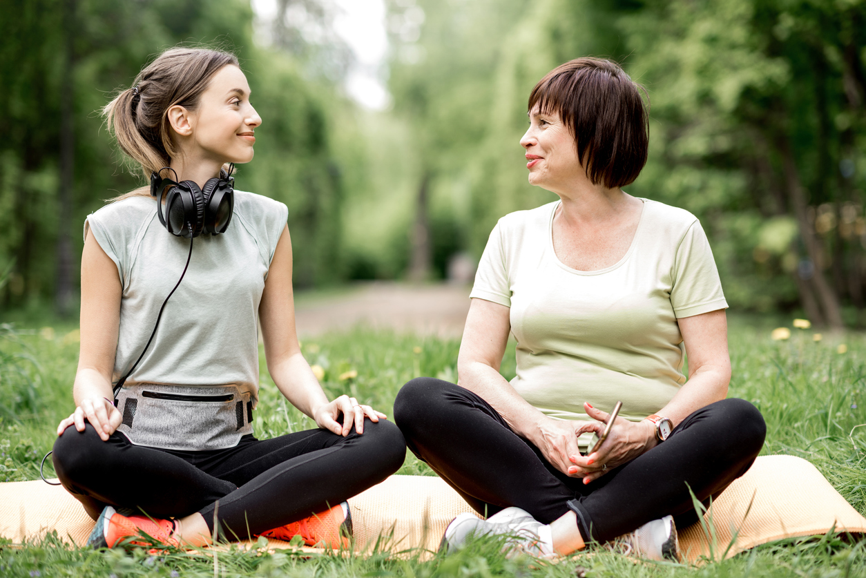 Two ladies doing yoga in a park