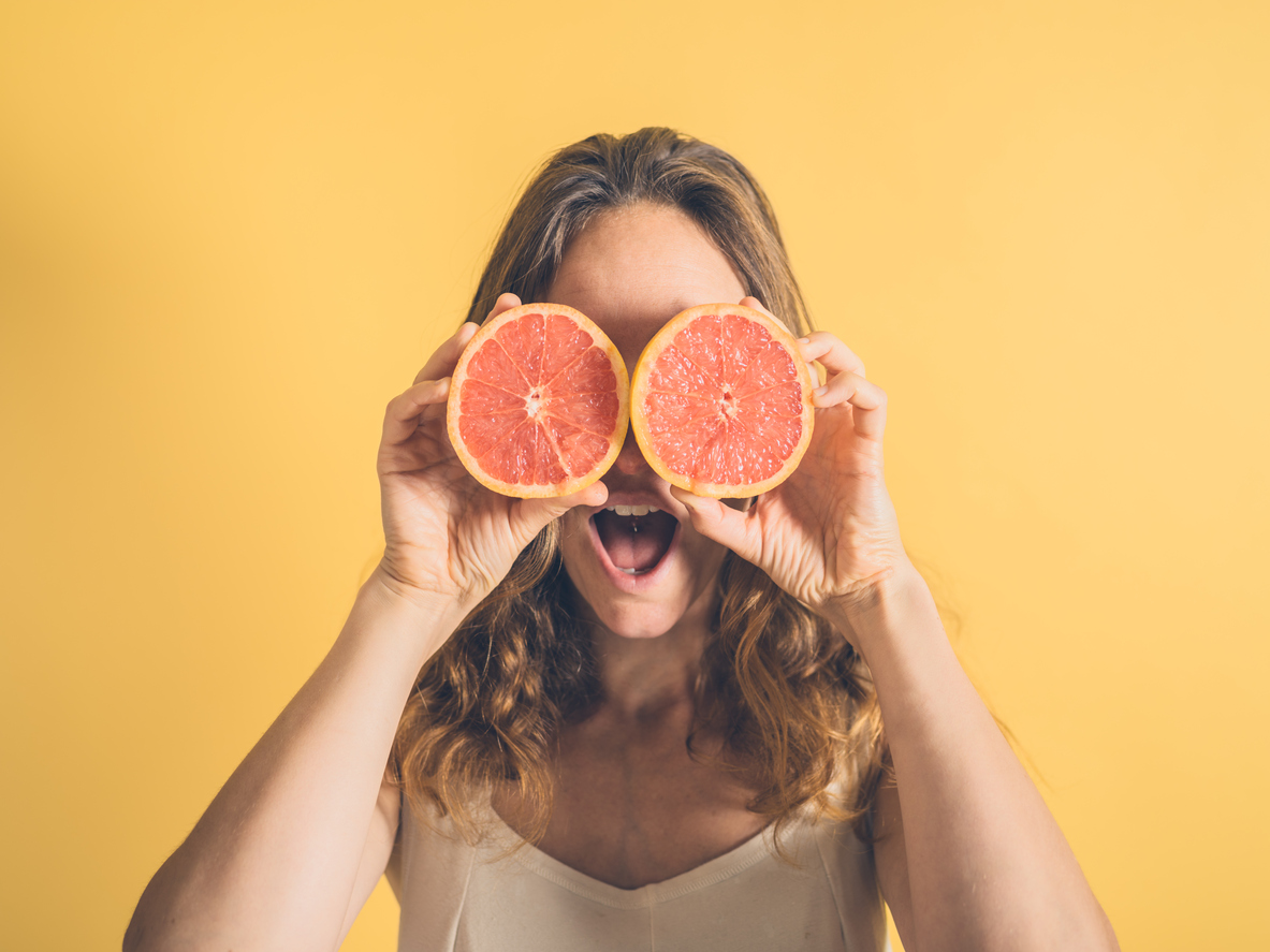 A woman using grapefruit as a pair of comedy eyes