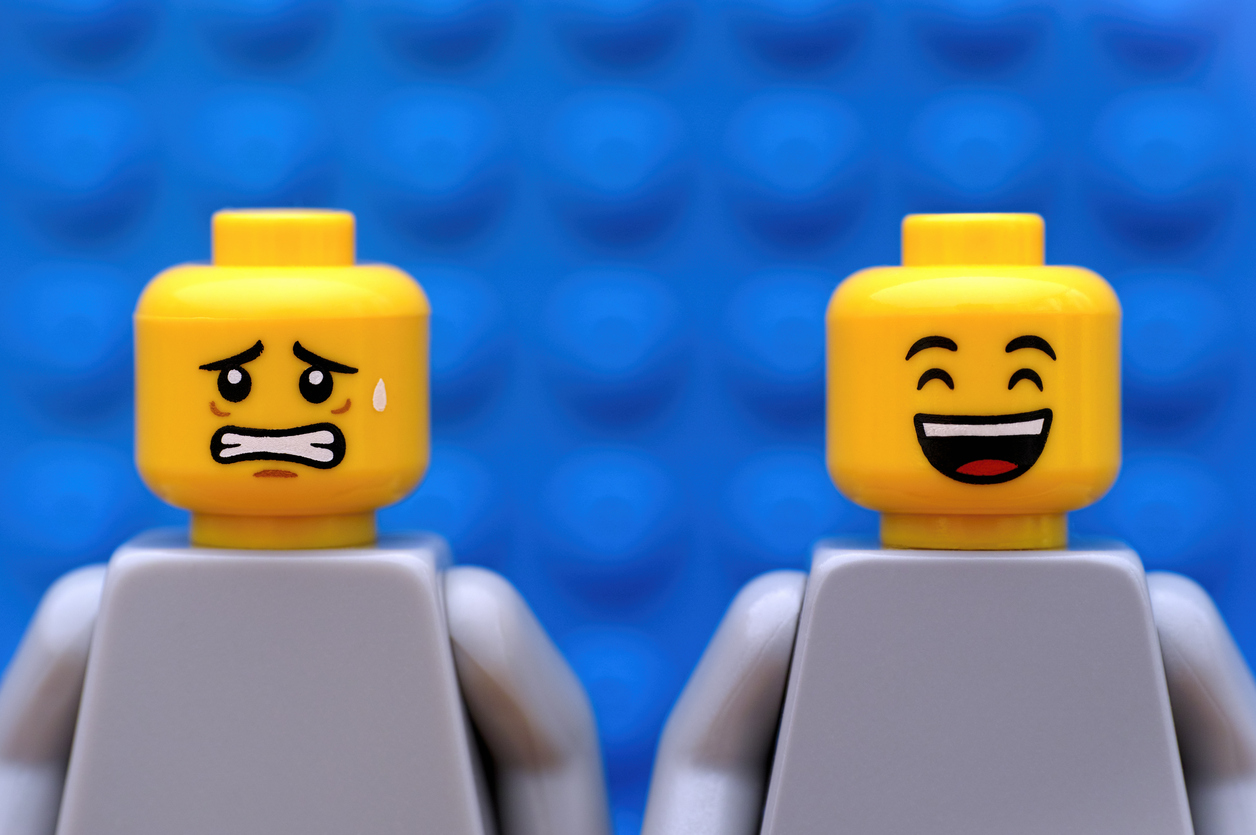 Two LEGO figures, one laughing, one looks uneasy